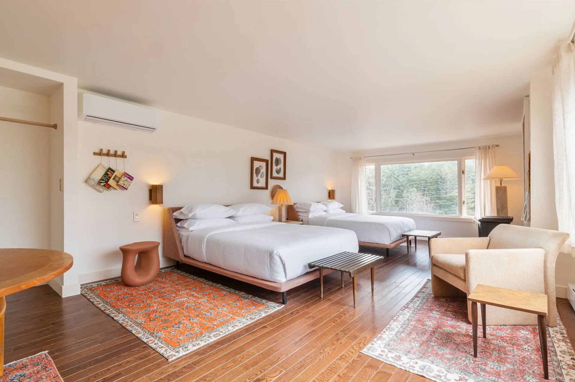 A double queen room with light and airy decor and natural wall art.