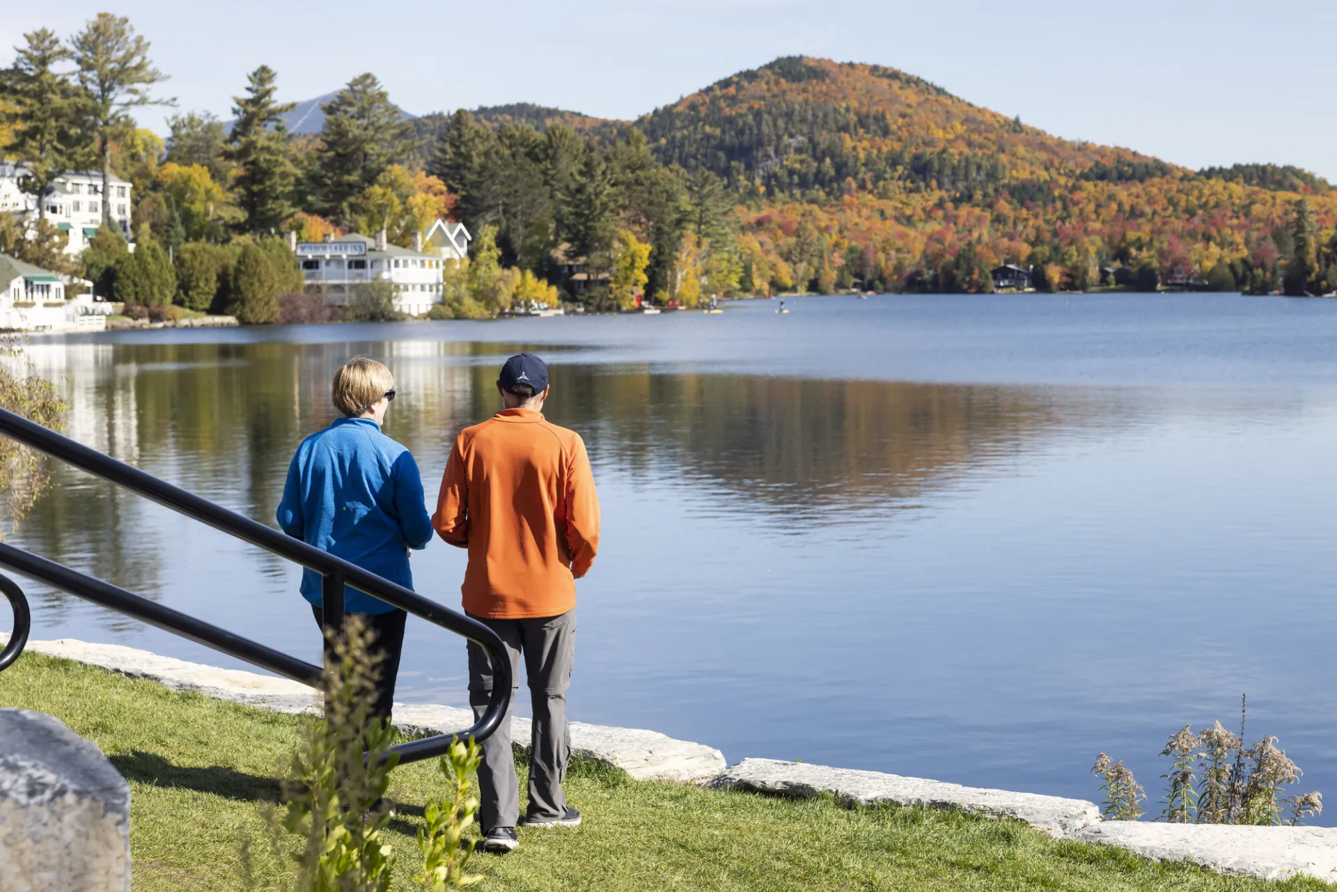 Two people look at the view of a mountain across a lake
