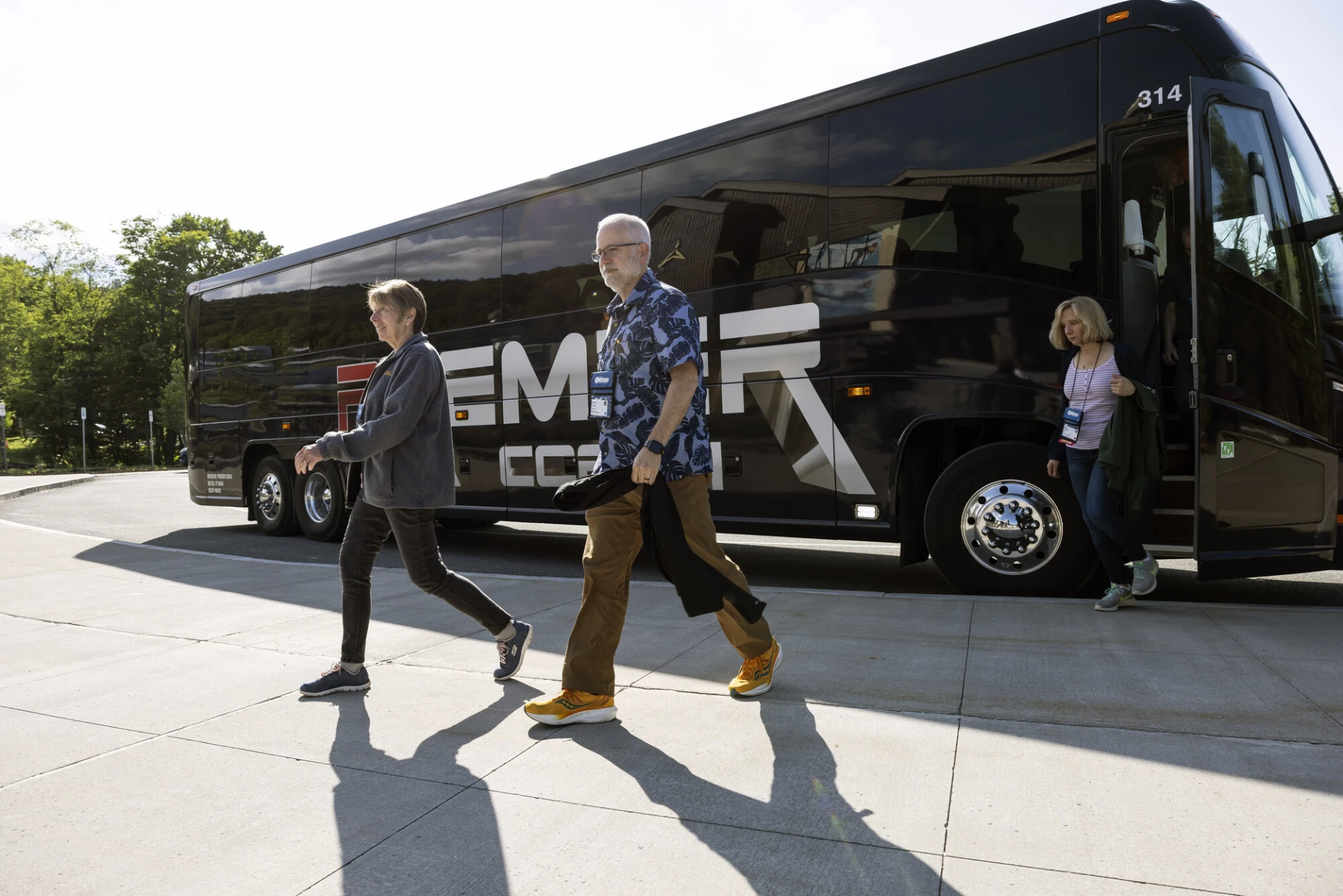 A man and woman walk off a bus. 