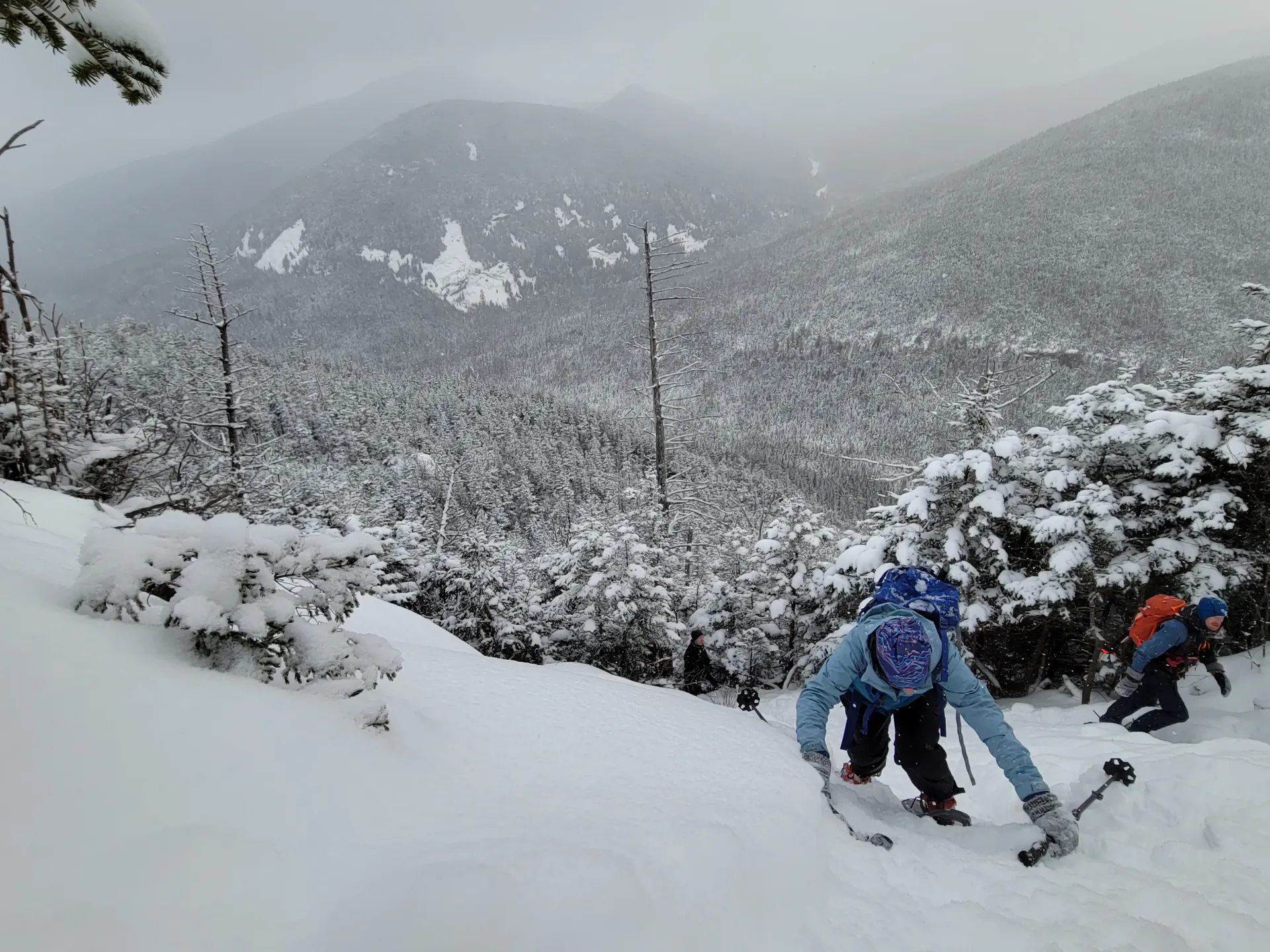 Hikers going up a snow covered cliff