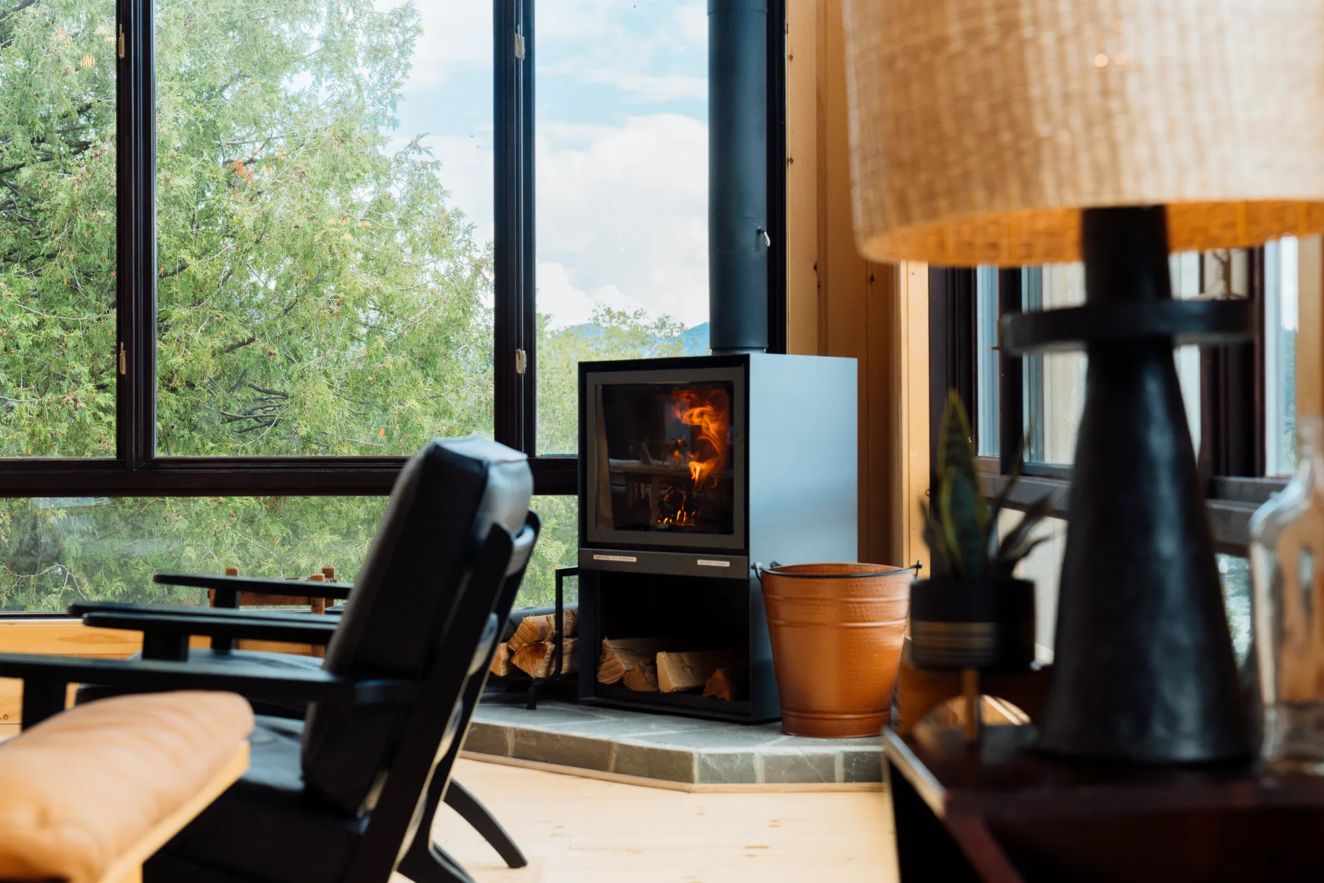 A roaring fire place in the great room with the large windows facing Mirror Lake.