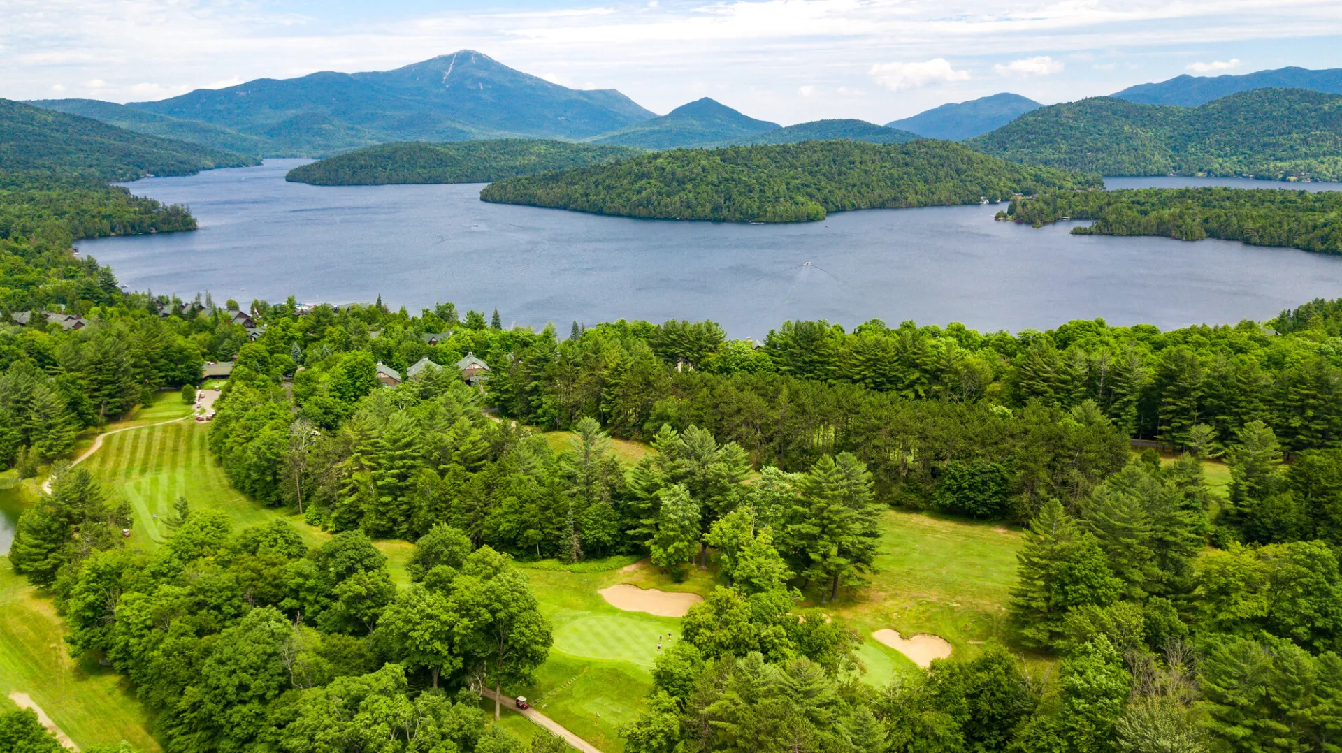 Aerial view of a large lake with a golf course beside it