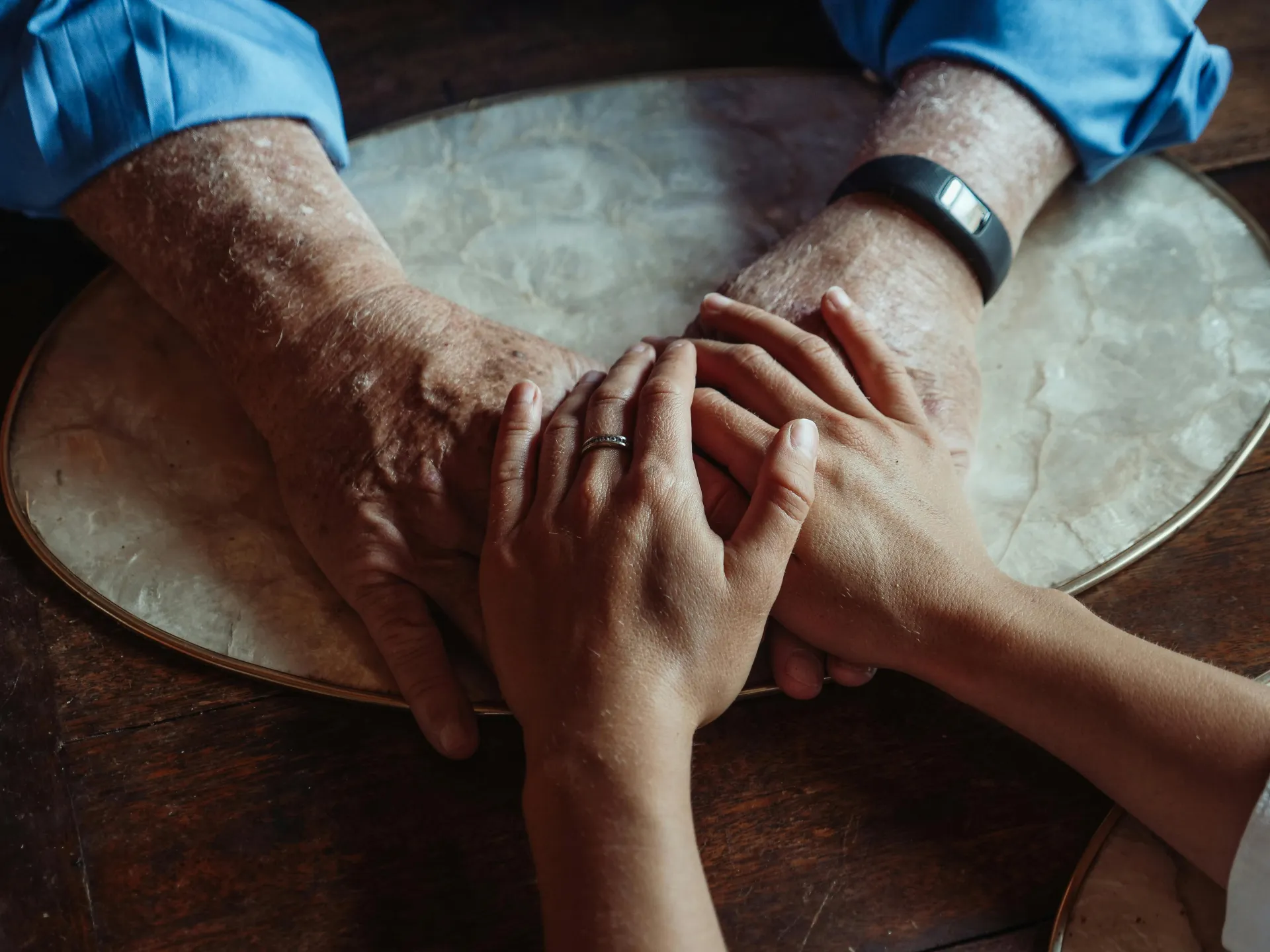 Two people holding hands over a table