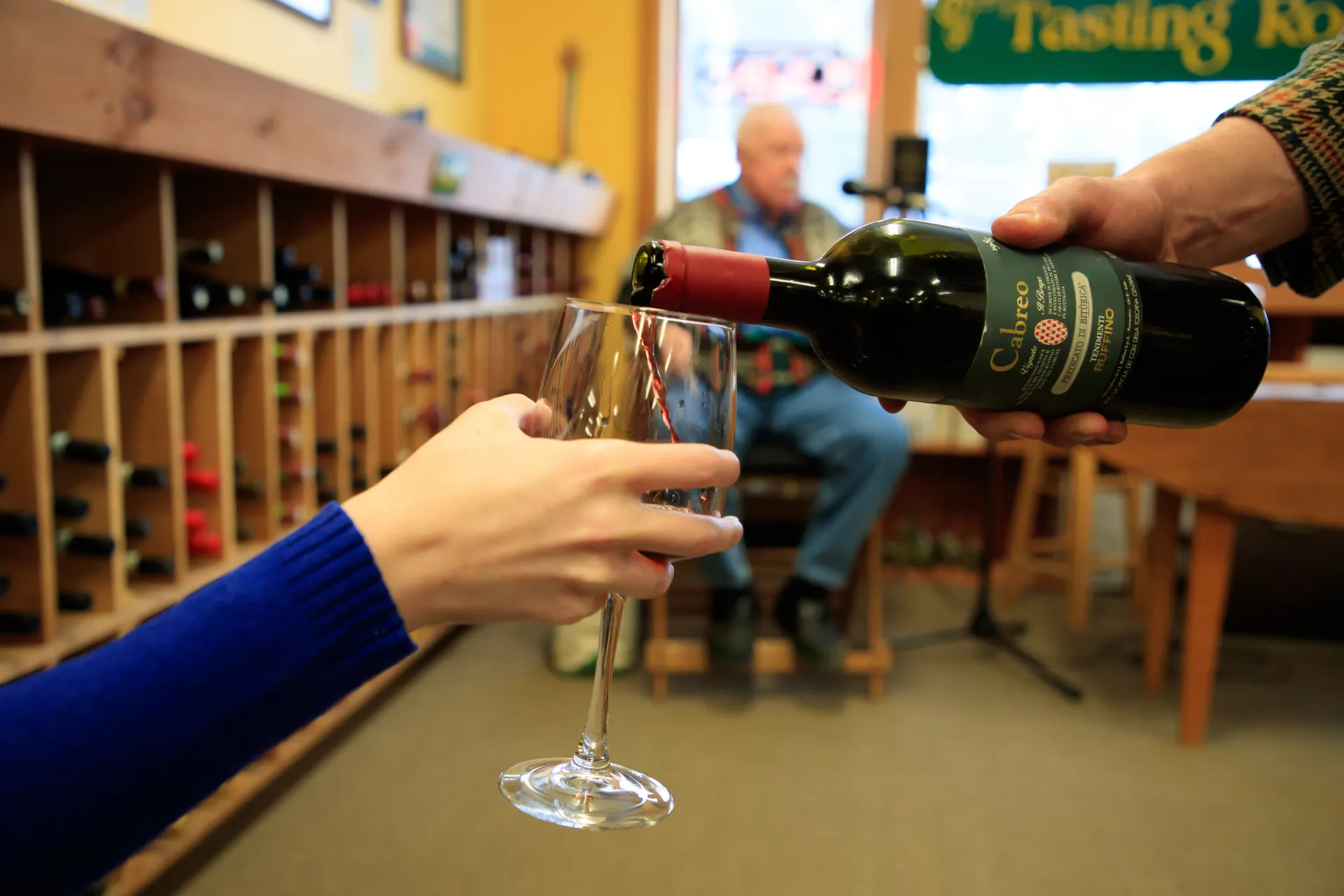 Wine being poured into a glass at a Lake Placid wine shop.
