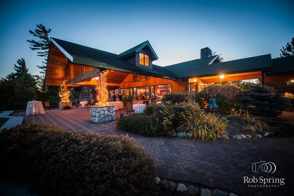 The warmly illuminated Golf House at the Lake Placid Club at dusk.