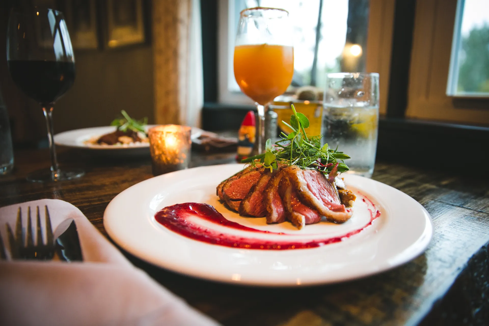 Duck breast on a white plate.