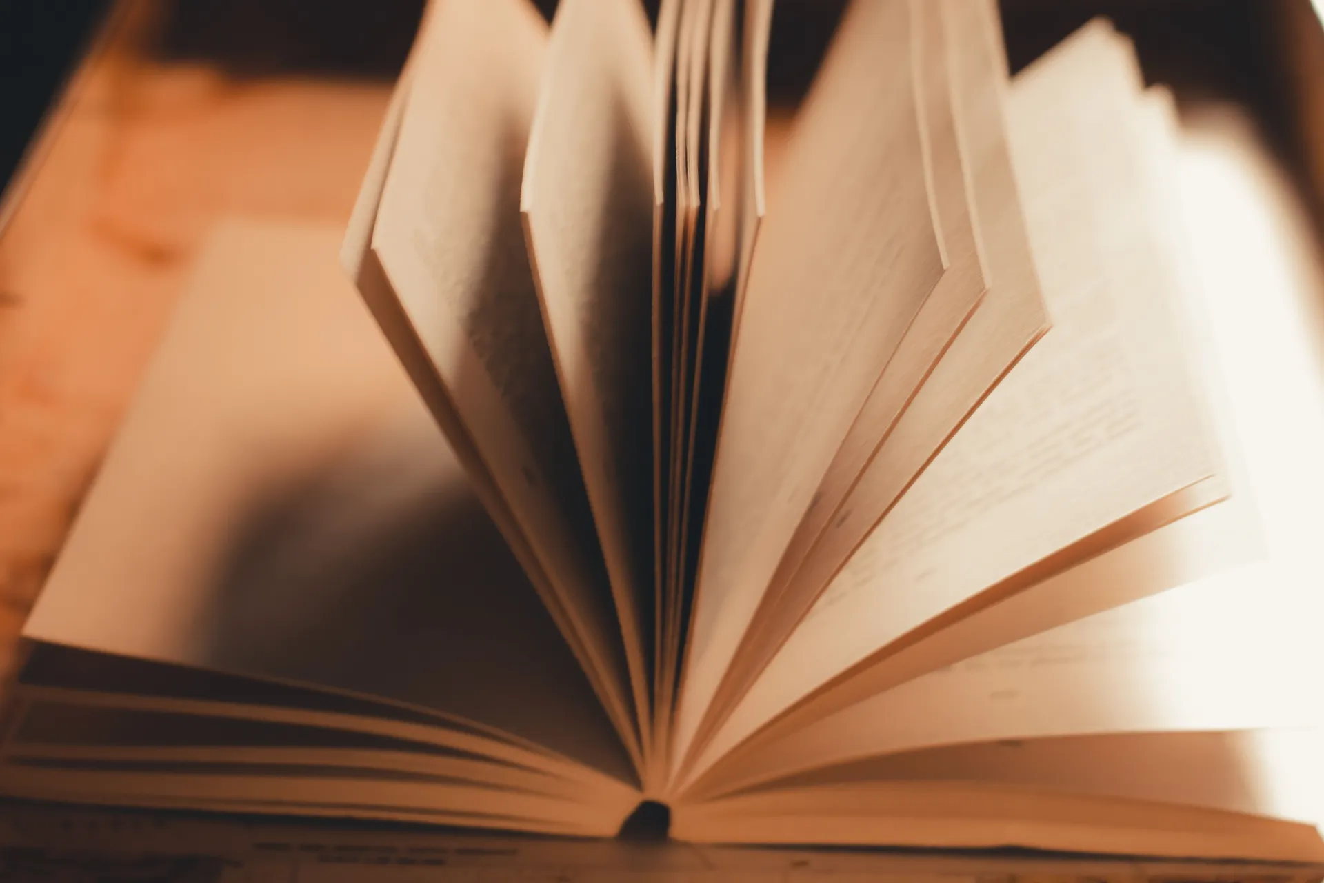 Stock image of open book on table with pages turning