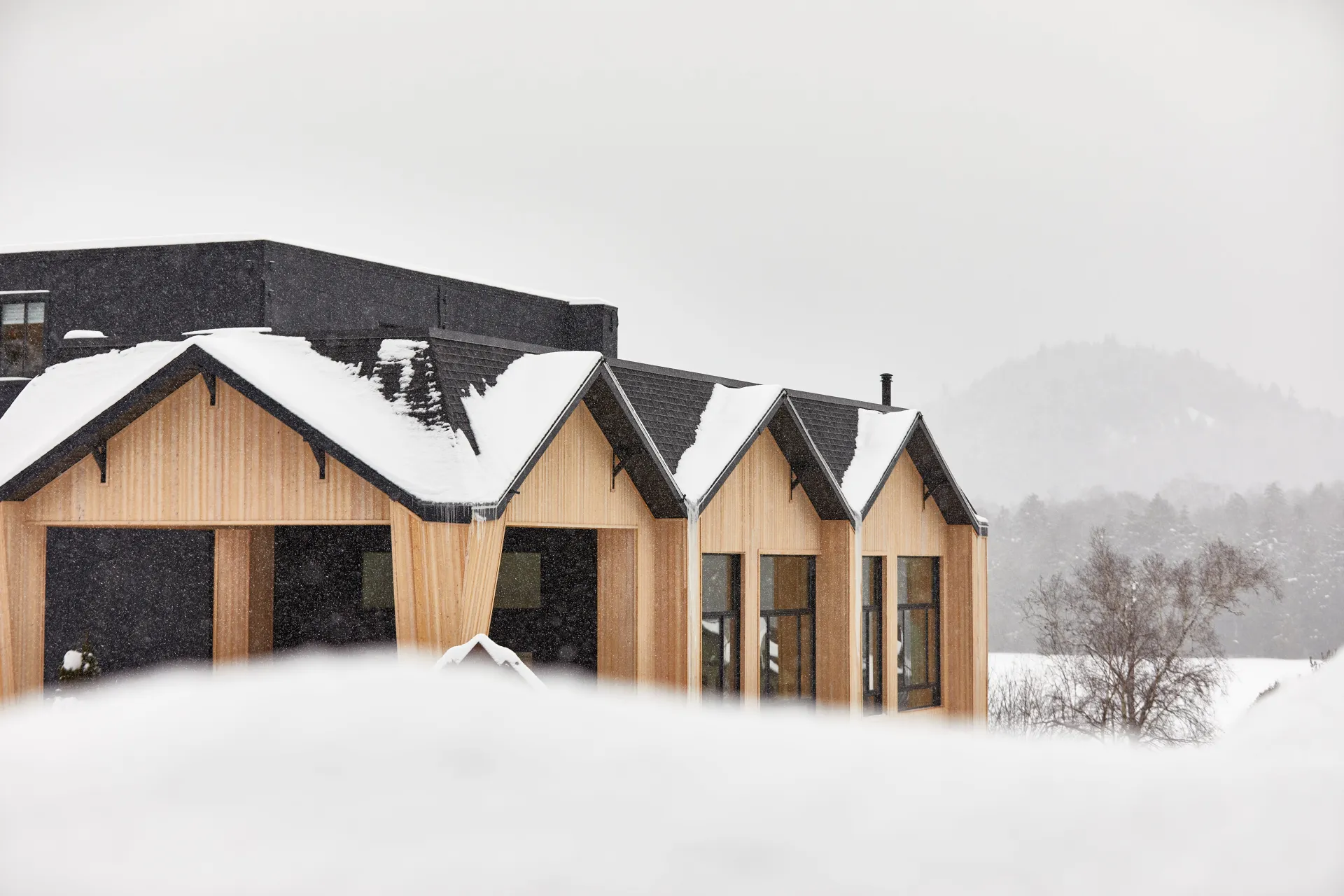 A view of the exterior of the lounge with huge windows and fresh snow.