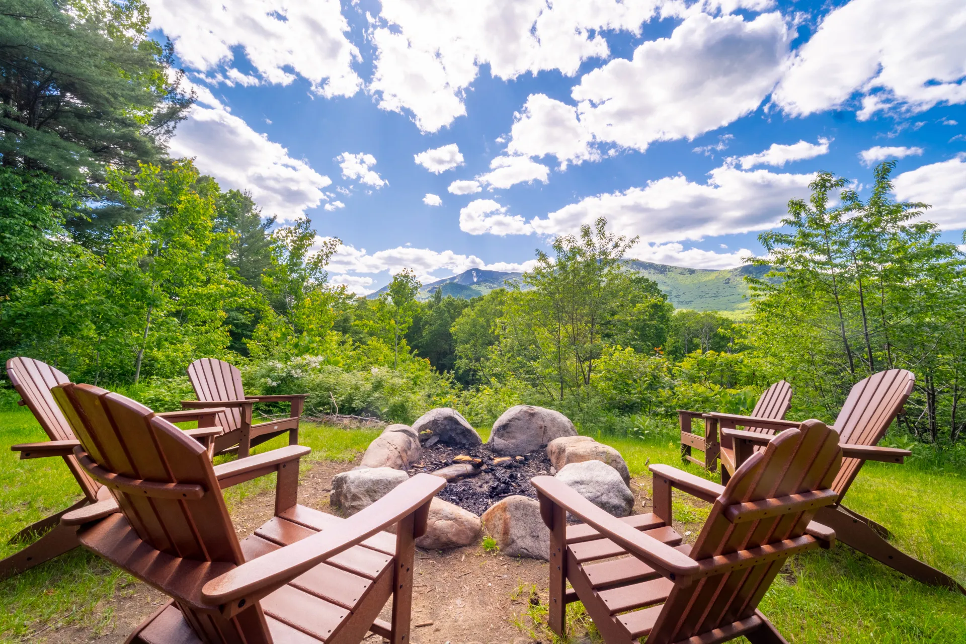 Adirondack chairs around a fire pit with Mountain Views