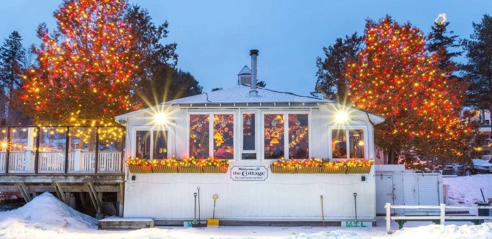 The white building of the Cottage with colorful window boxes.