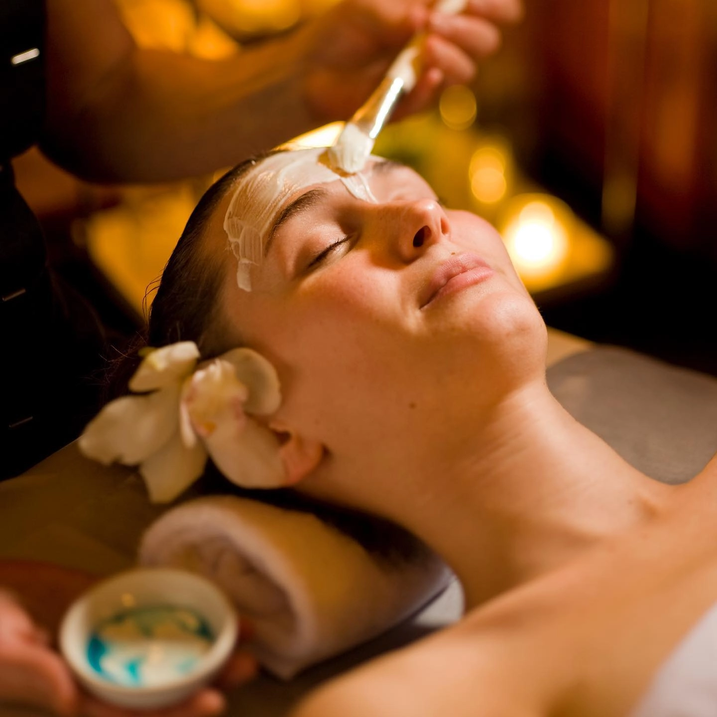 A woman receives a facial mask.