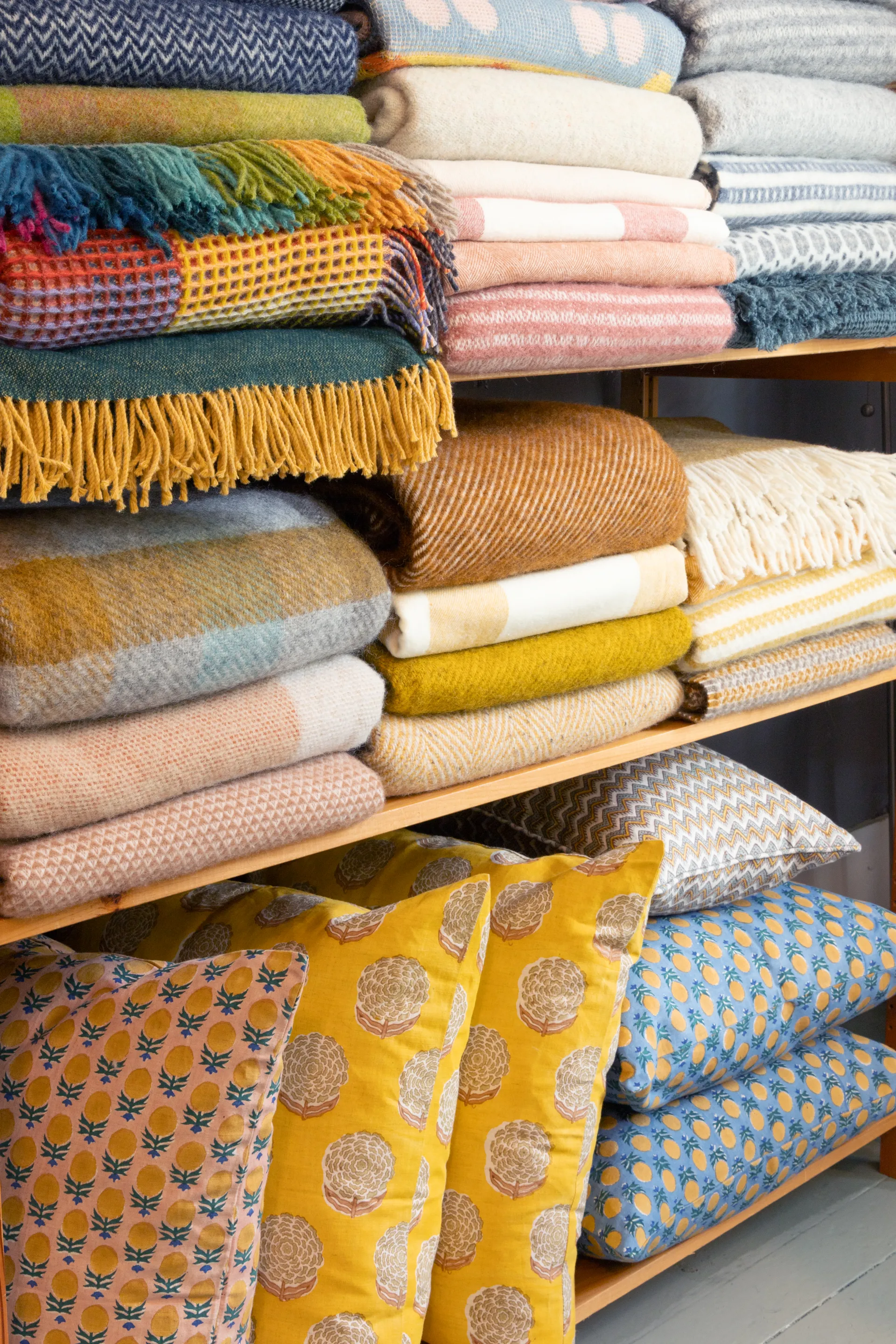 Fine wool blankets and complimentary pillows sit on a shelf