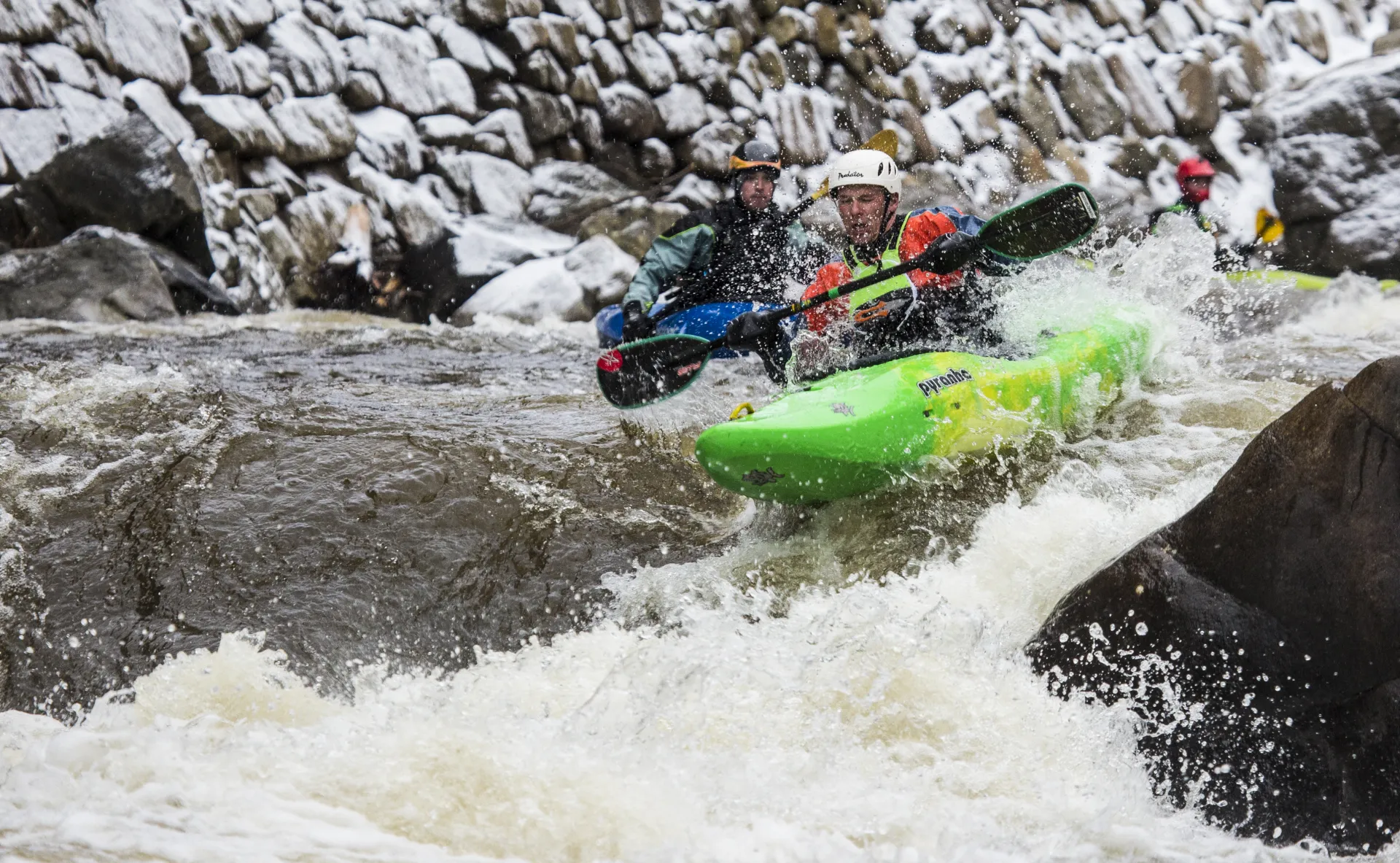 Two men white water raft in rapids.
