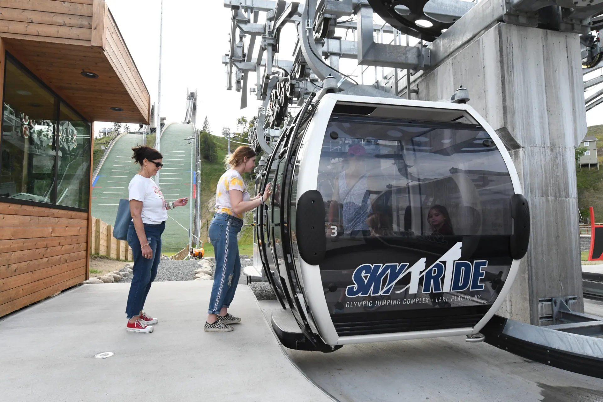 People wait to ride the gondola at the Olympic Jumping Complex
