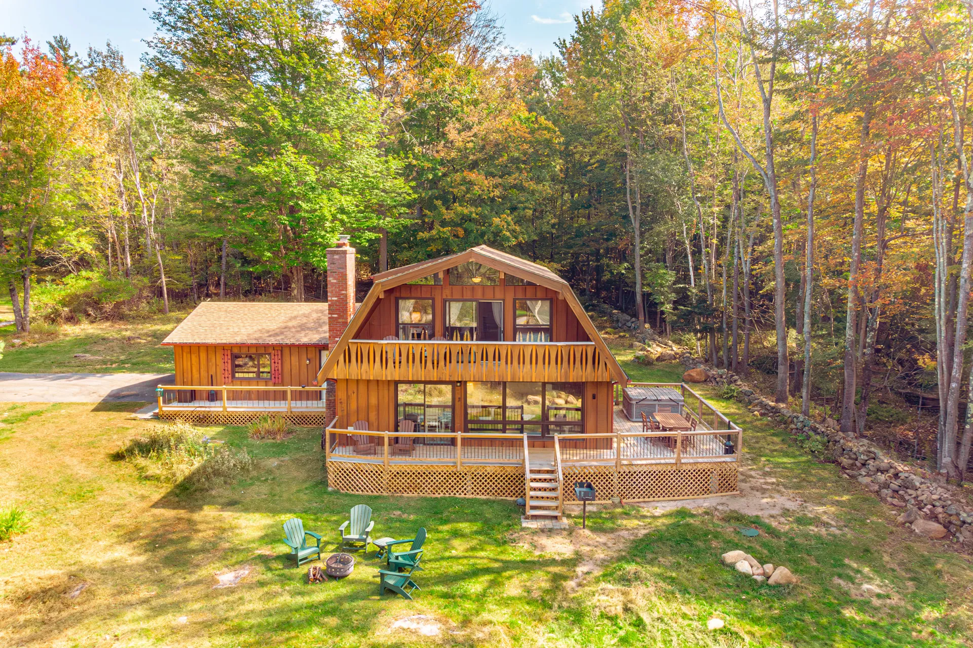 Exterior view of the ADK Whiteface Chalet featuring two levels with balcony, porch and patio by garage.