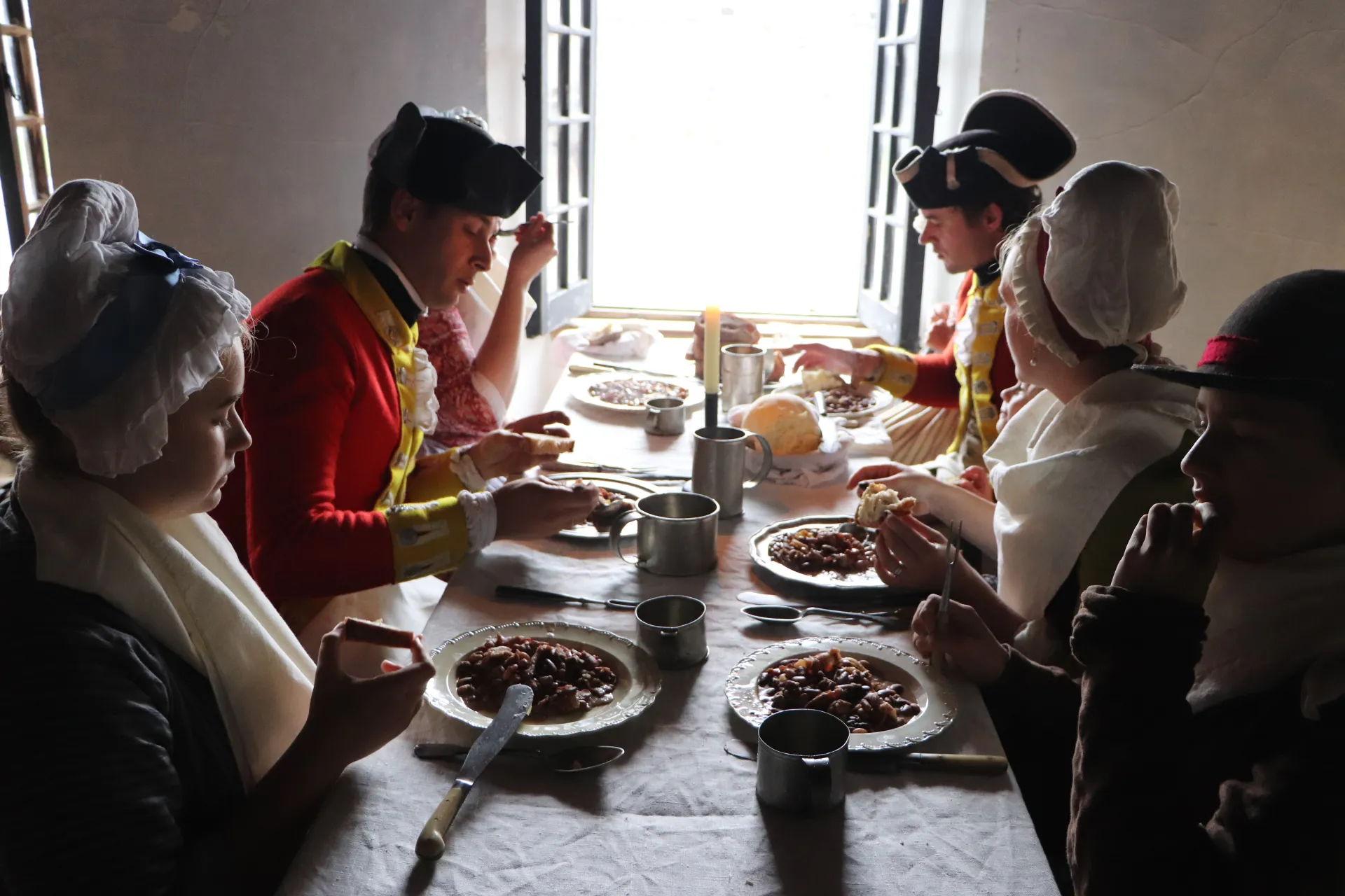 Reenactment performers eat a traditional British meal in costume.