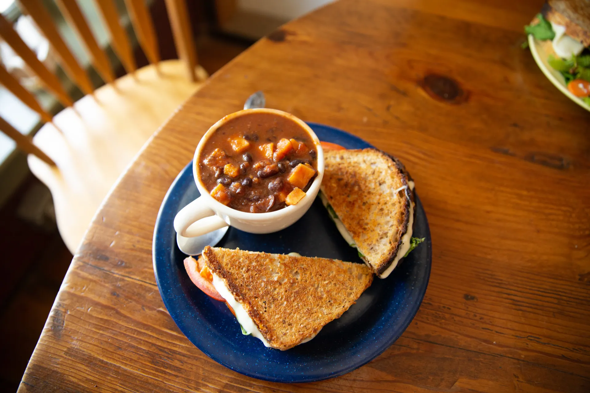 Plated sandwich and soup on a table.