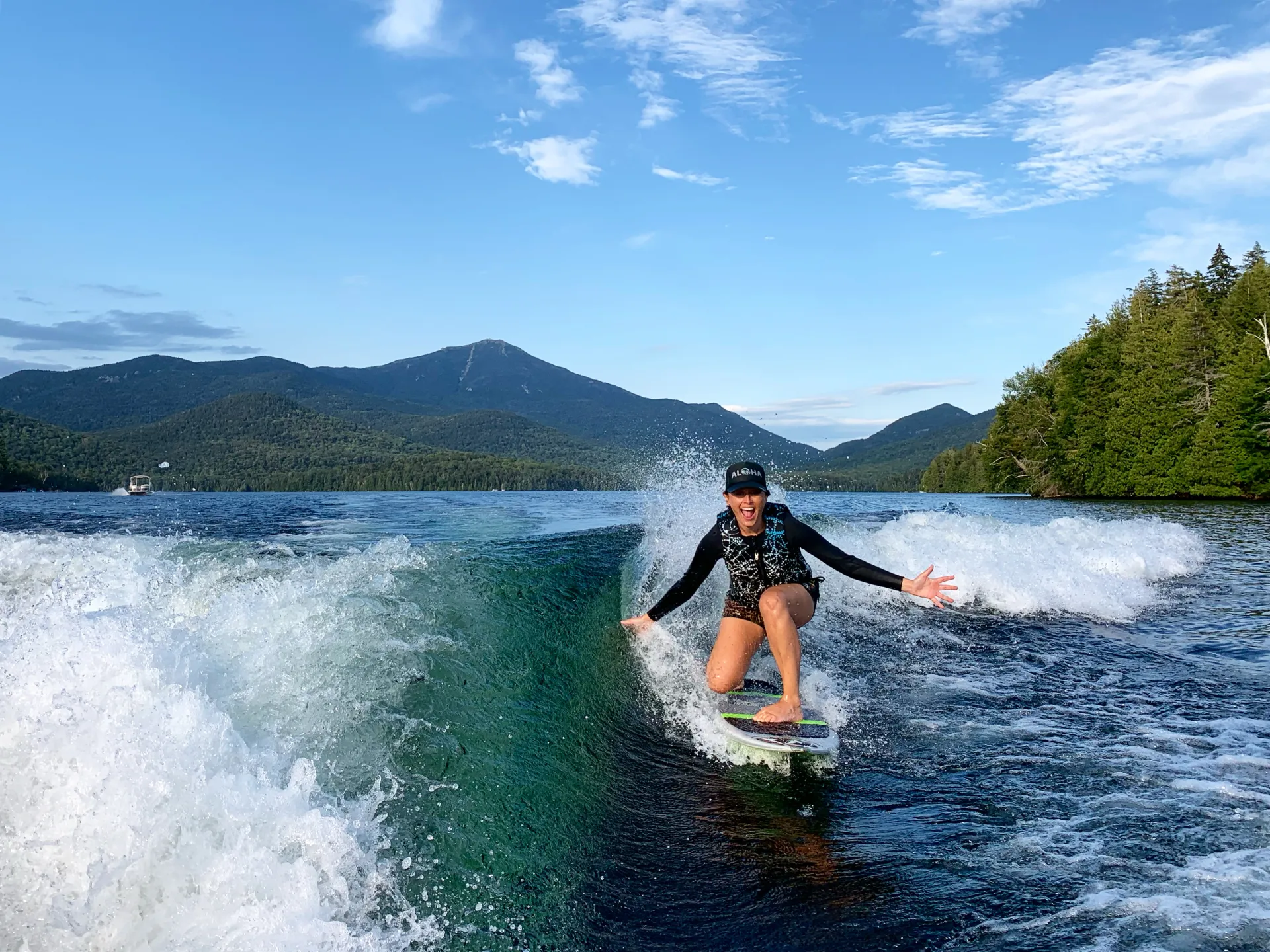 A person surfs the wake behind a boat.