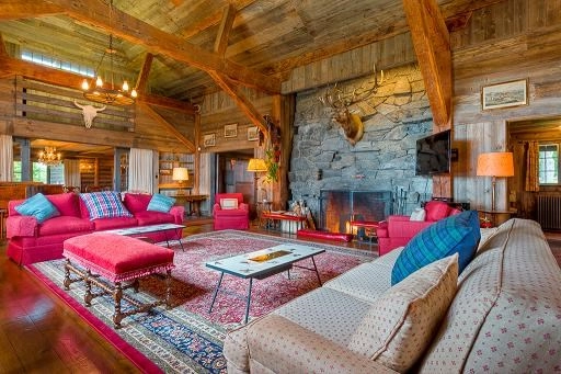 Grand livingroom space with large stone fireplace and ample seating.
