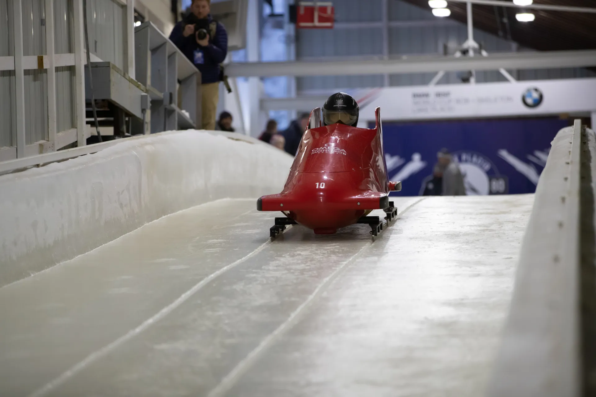 A person in a bobsled going down a track.