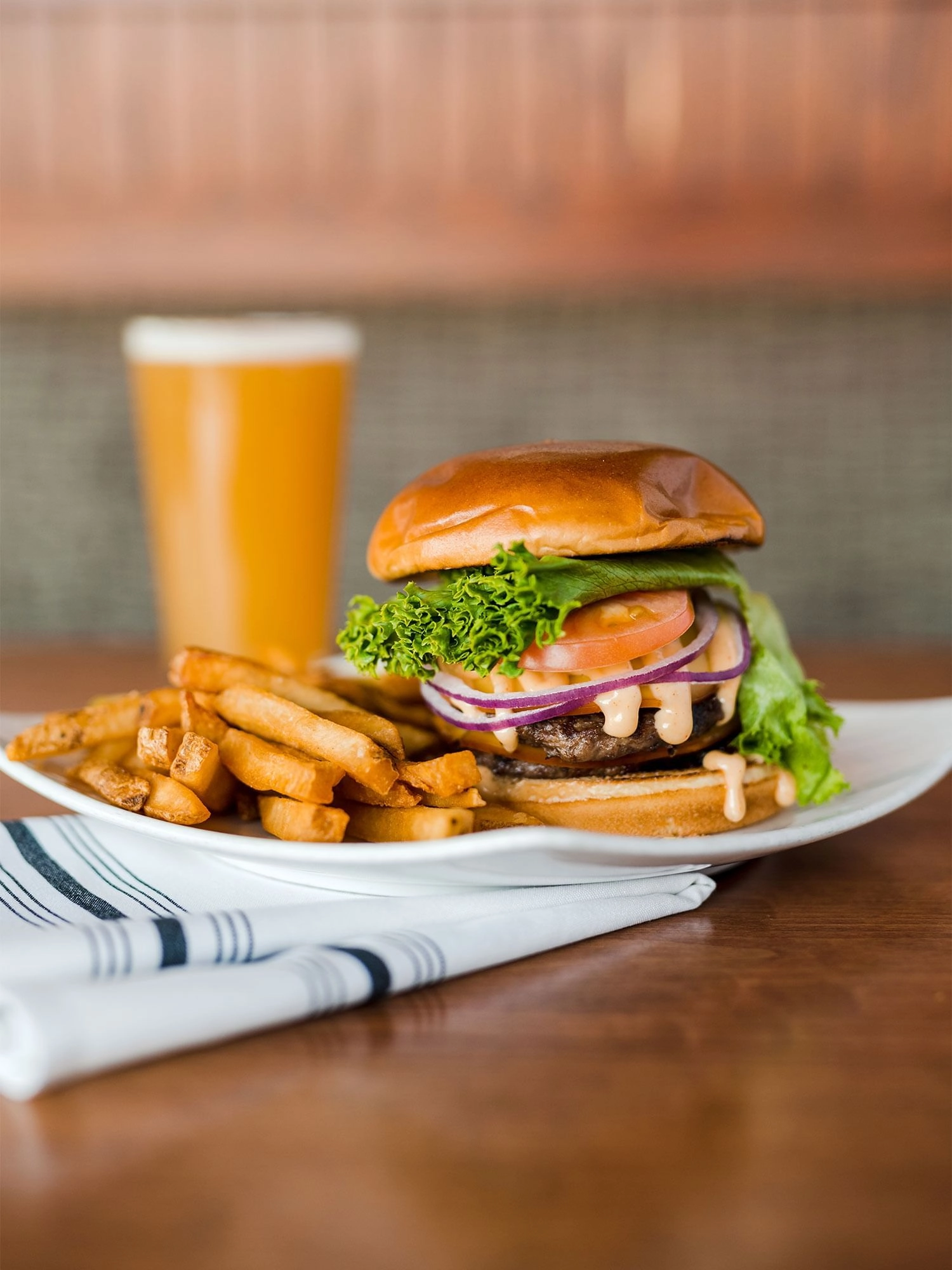 A juicy burger with all the fixin's, thick cut french fries and a luscious freshly poured beer.