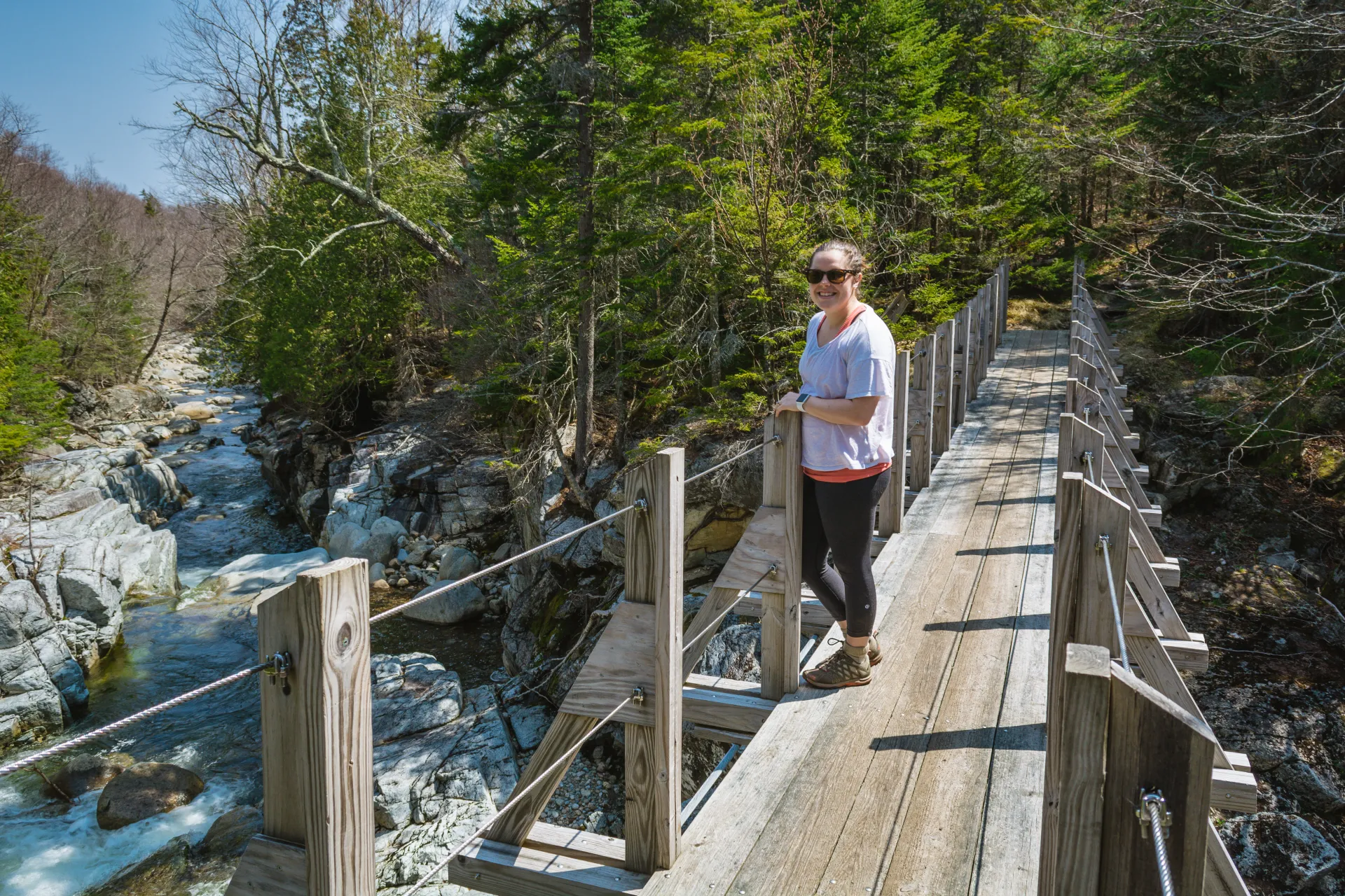 A hiker on the bridge across Johns Brook