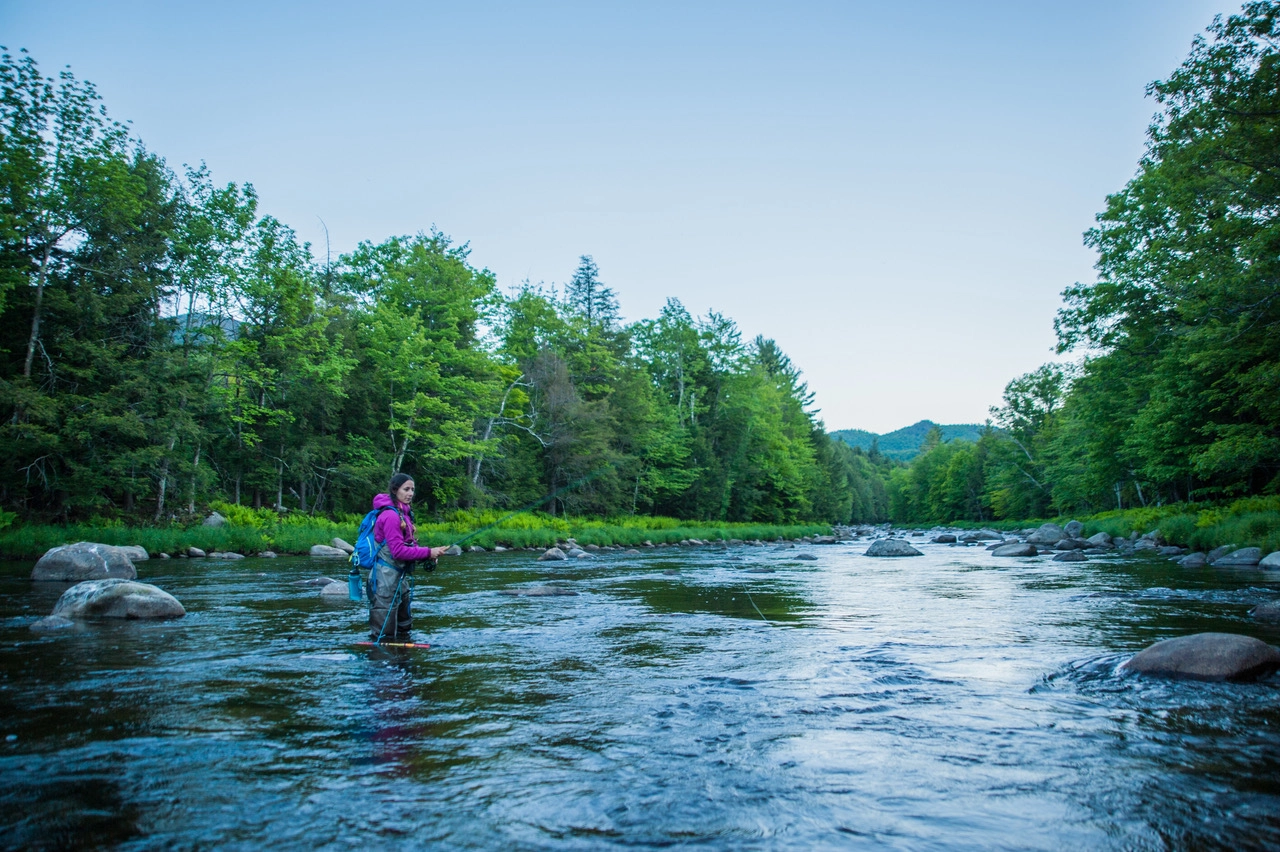A woman fly fishing in a river.