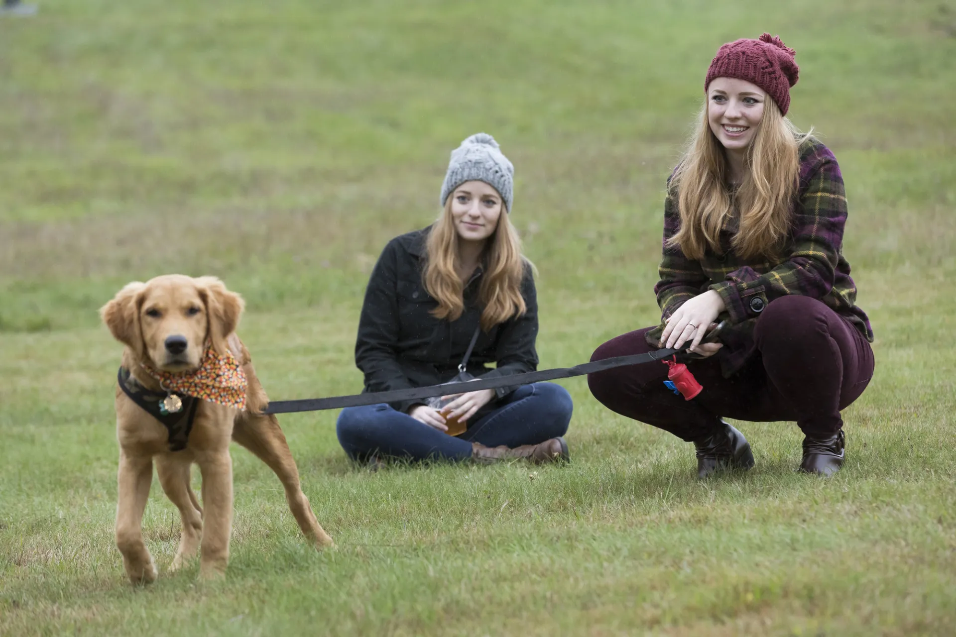 Two women with a leashed puppy.