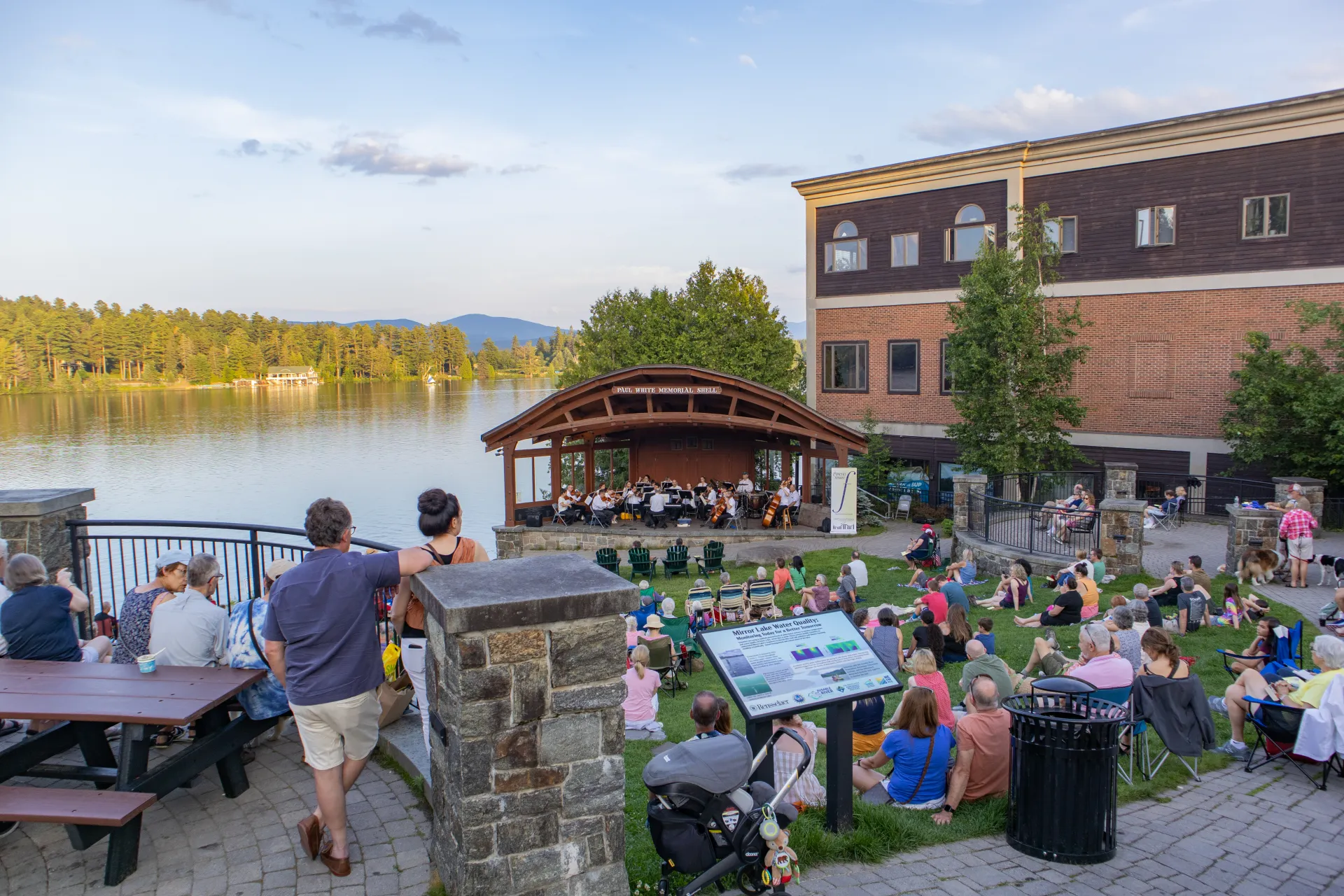 Park concert overlooking green with mountains and lake surrounding Credit to: Jacob Rushlow