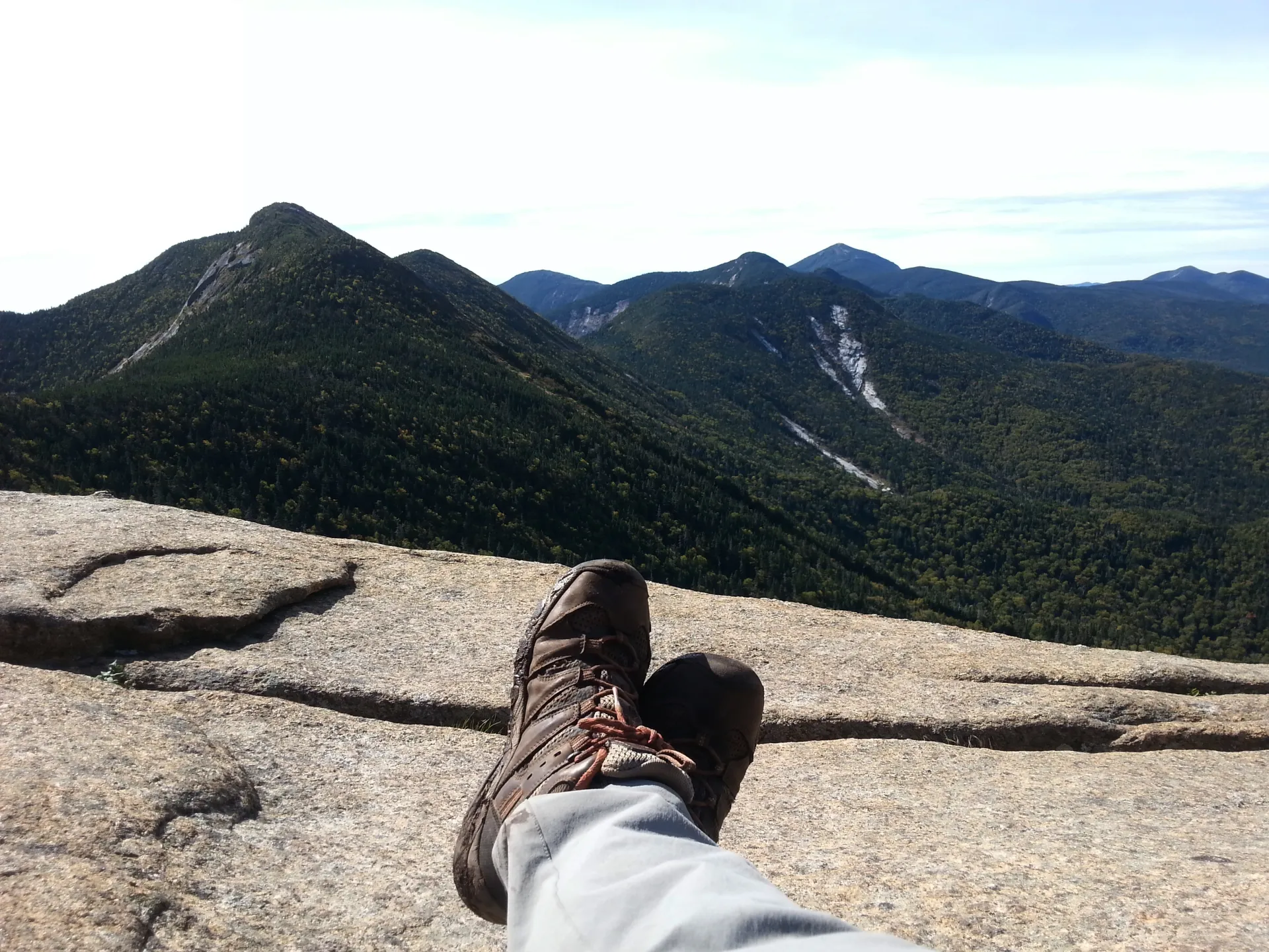 A hiker's boots in the frame of a photo of mountains
