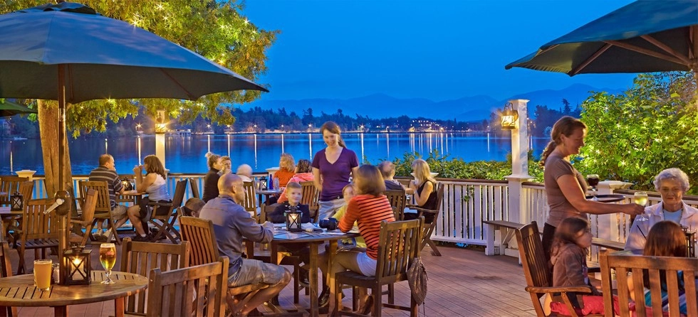 A table full of family sits on the deck overlooking Mirror Lake.