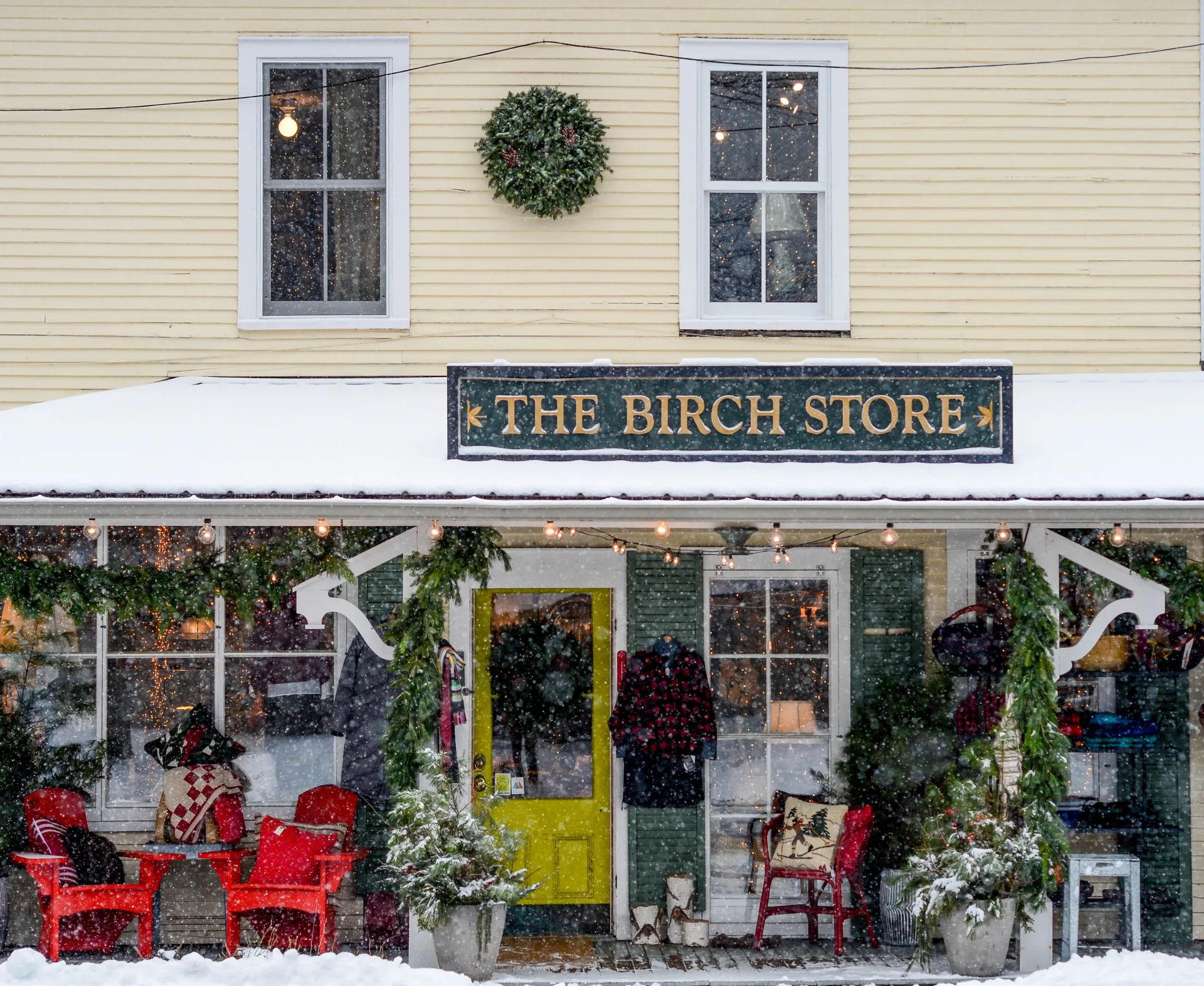 The exterior of The Birch Store blanketed in fresh white snow and decked out with garland for the holiday season