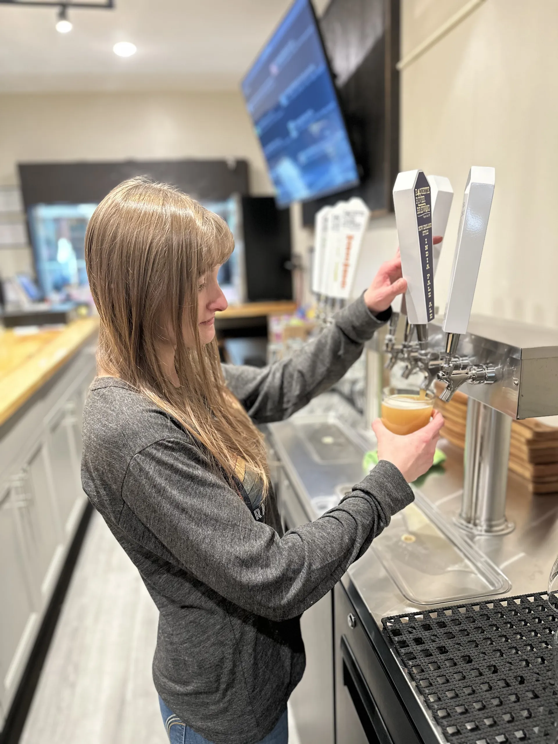 A woman pours a beer