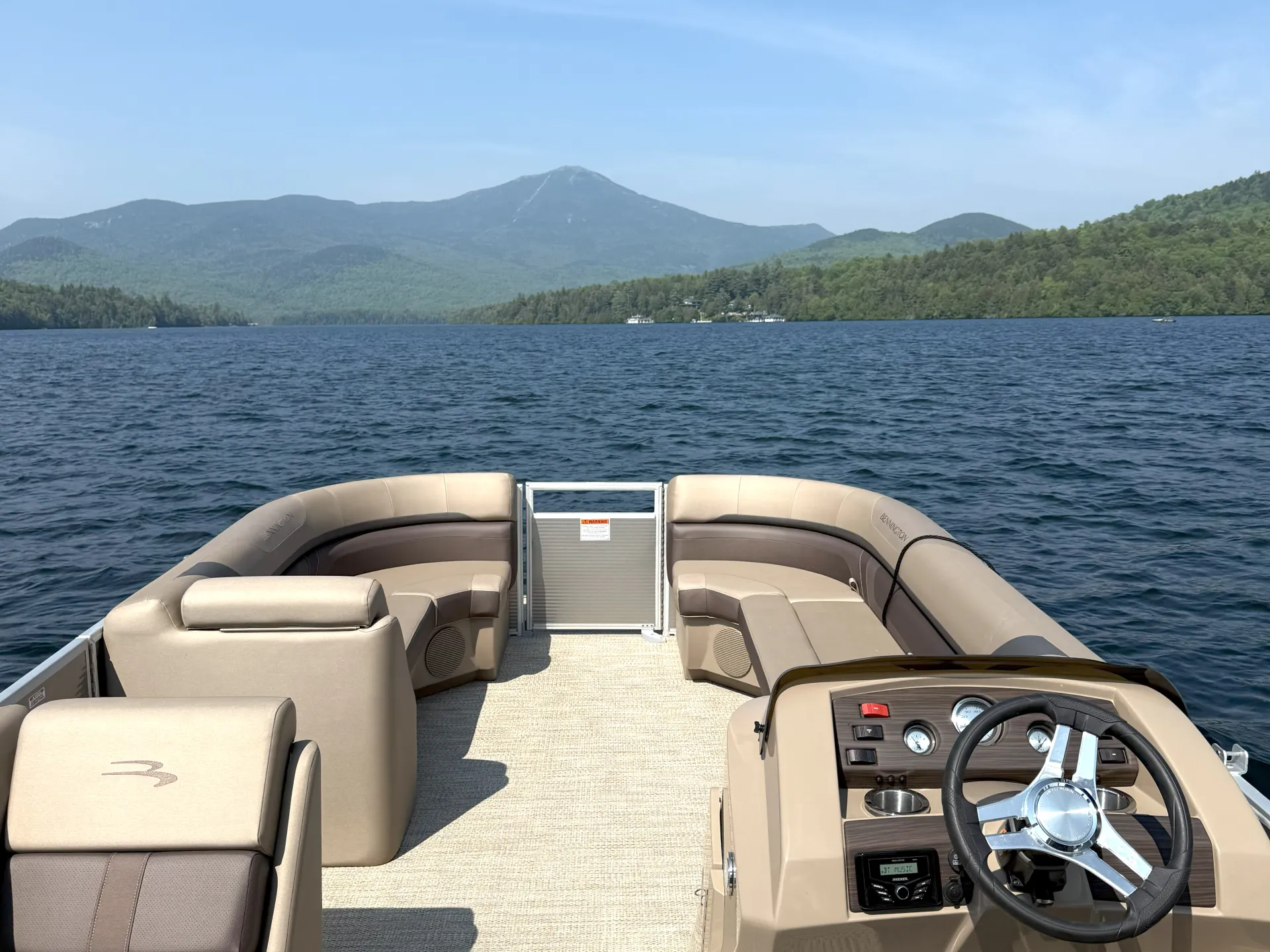 A view of a brown and caramel colored pontoon boat as though you are captaining