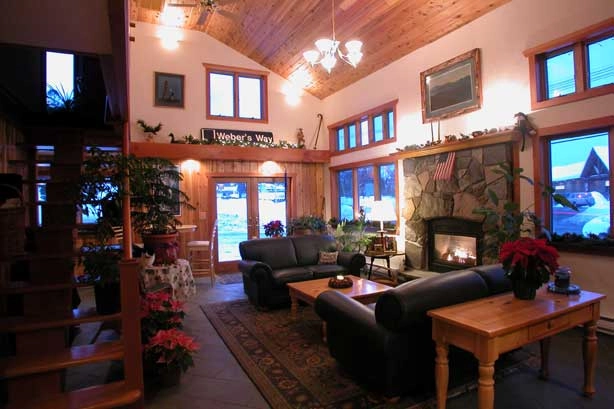 Large living spaces with couches and stone fireplace.