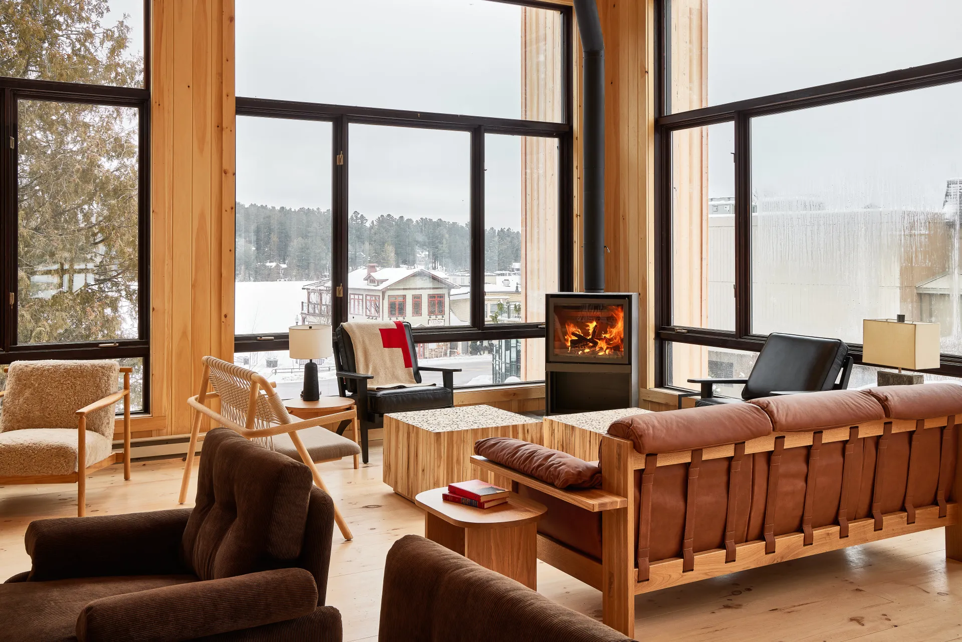 The corner of the main lounge and fireplace with huge windows looking out over Mirror Lake under fresh snow.
