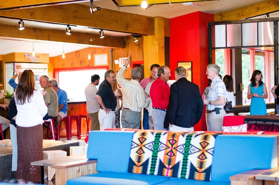 A group of people mingle in the lobby at Lake House.
