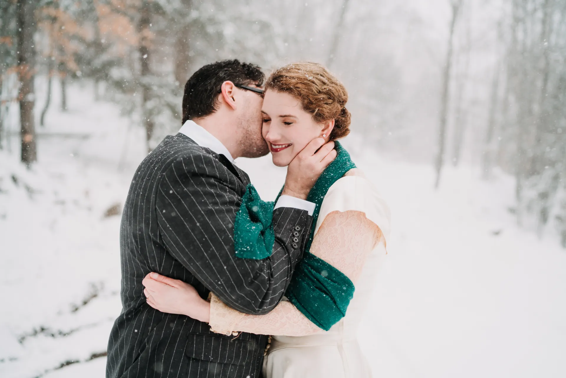 husband kissing his wife in the snow