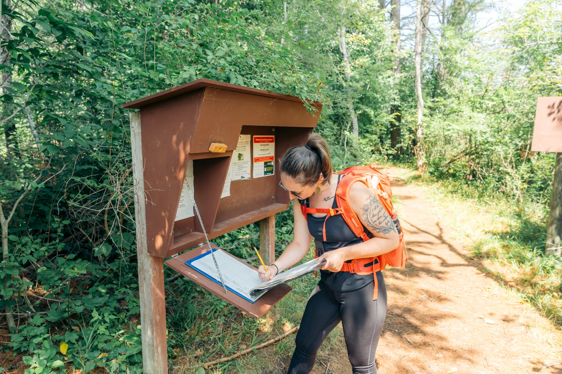 Hiker signs in at Rooster Comb trail register