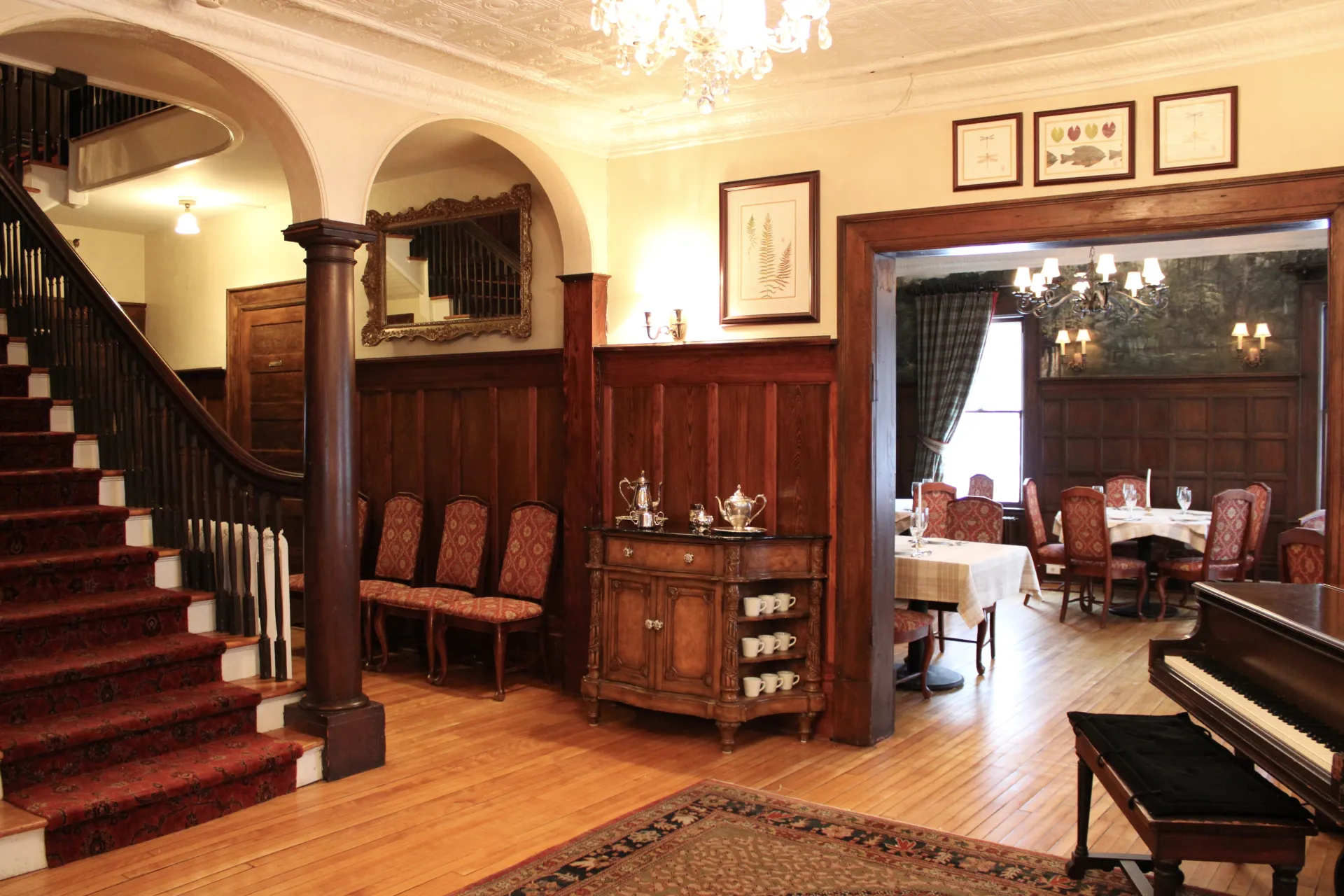 The foyer with dark trim and wainscoting and staircase.