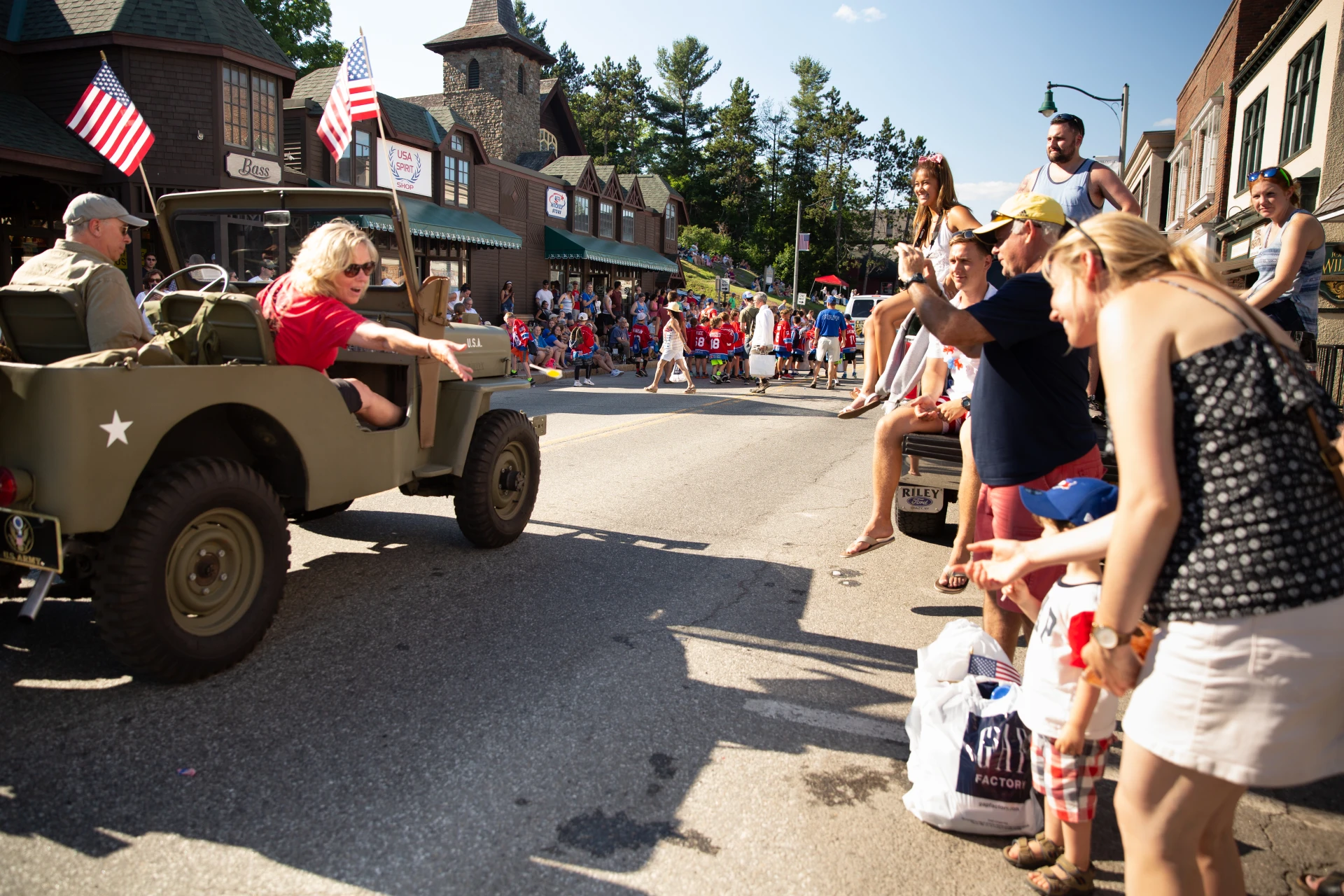 Car drives past parade crowd on Main Street in Lake Placid