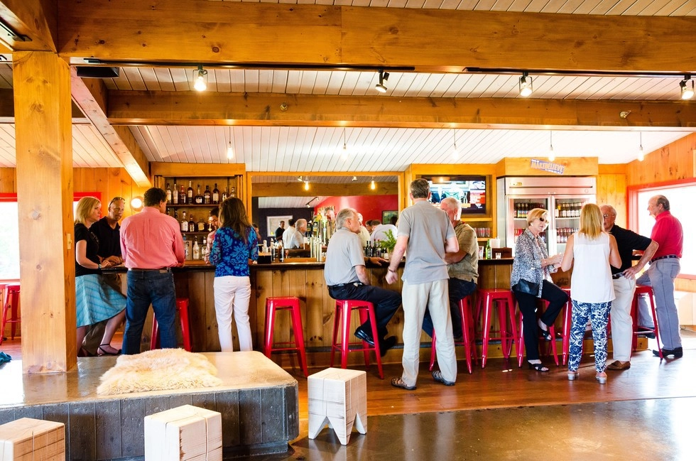 People enjoy the wood paneled bar.