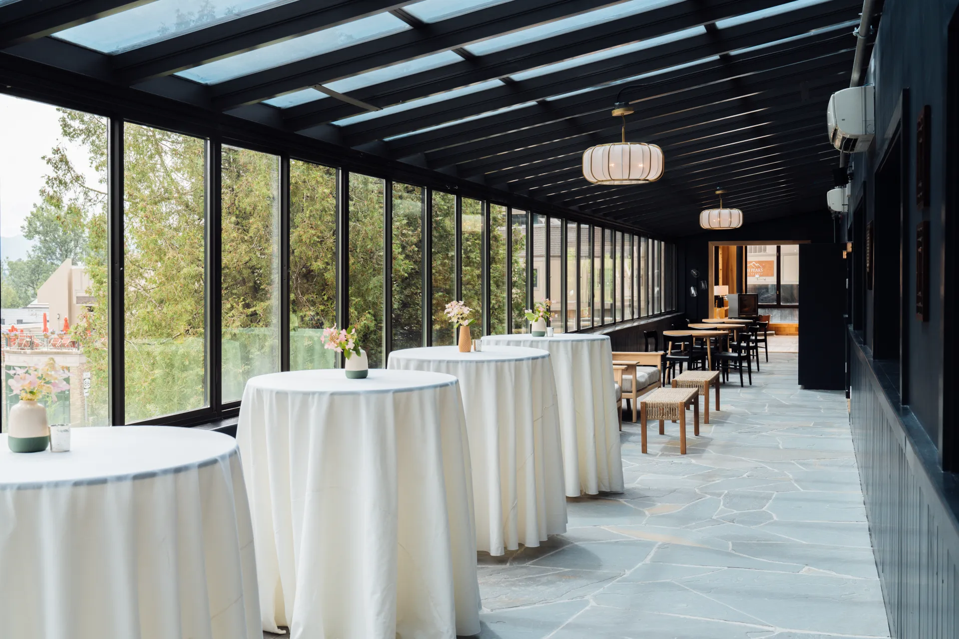 High tops in white linens under the solarium windows.