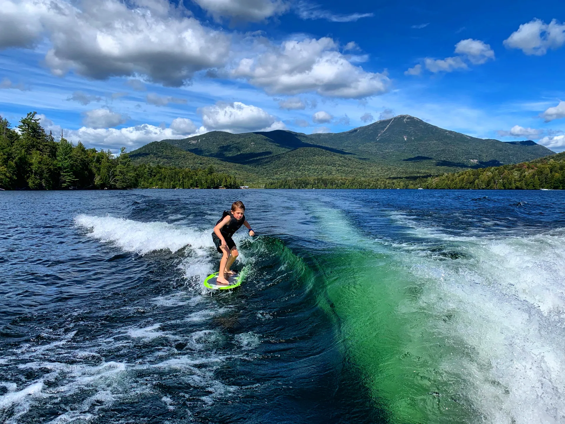  A person surfs the wake behind the boat.