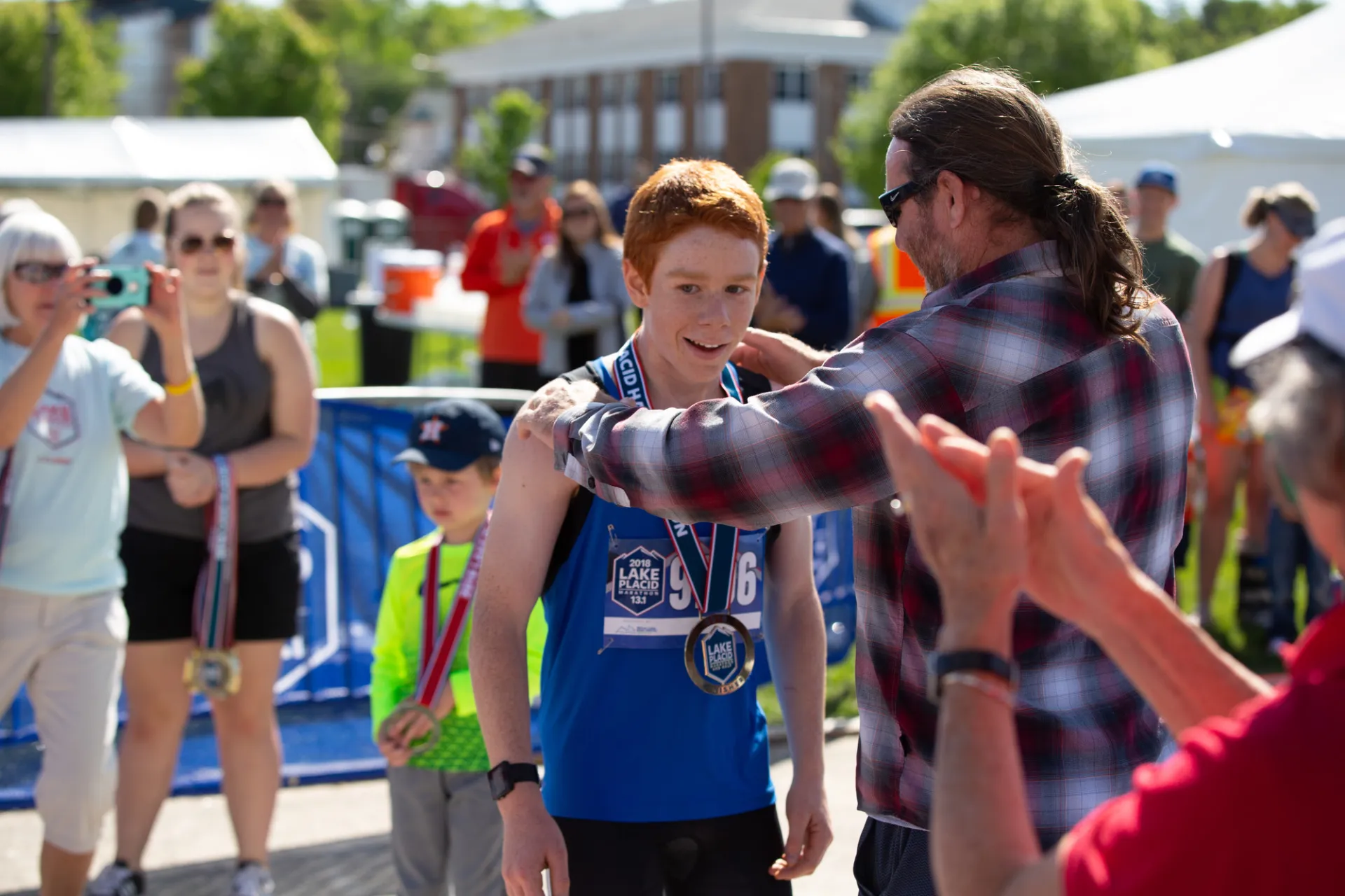 A father puts a finisher medal on this sun