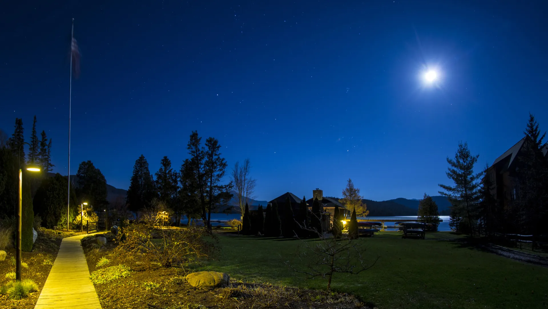 Whiteface Club grounds at night during a full moon, near a lake.