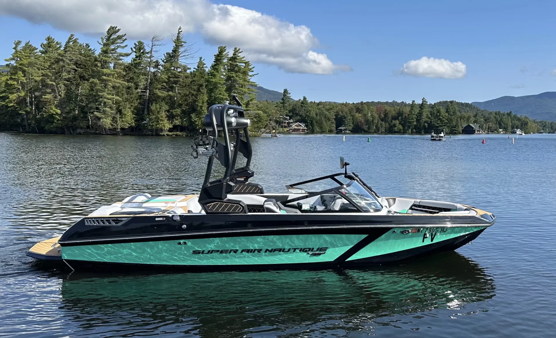 A shiny teal and black ski boat.