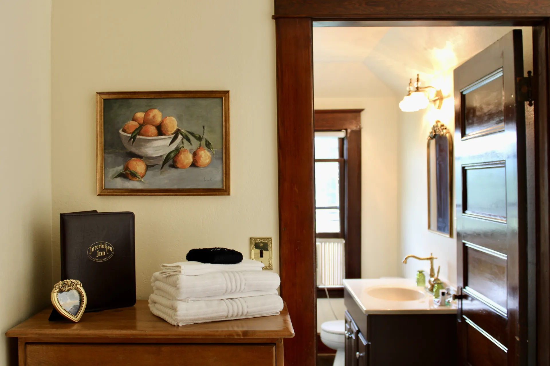 Towels on a dresser with a view into the restroom.