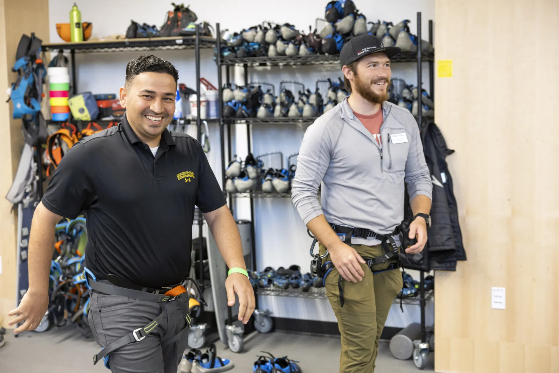 Two men walk and laugh in a gear shop.