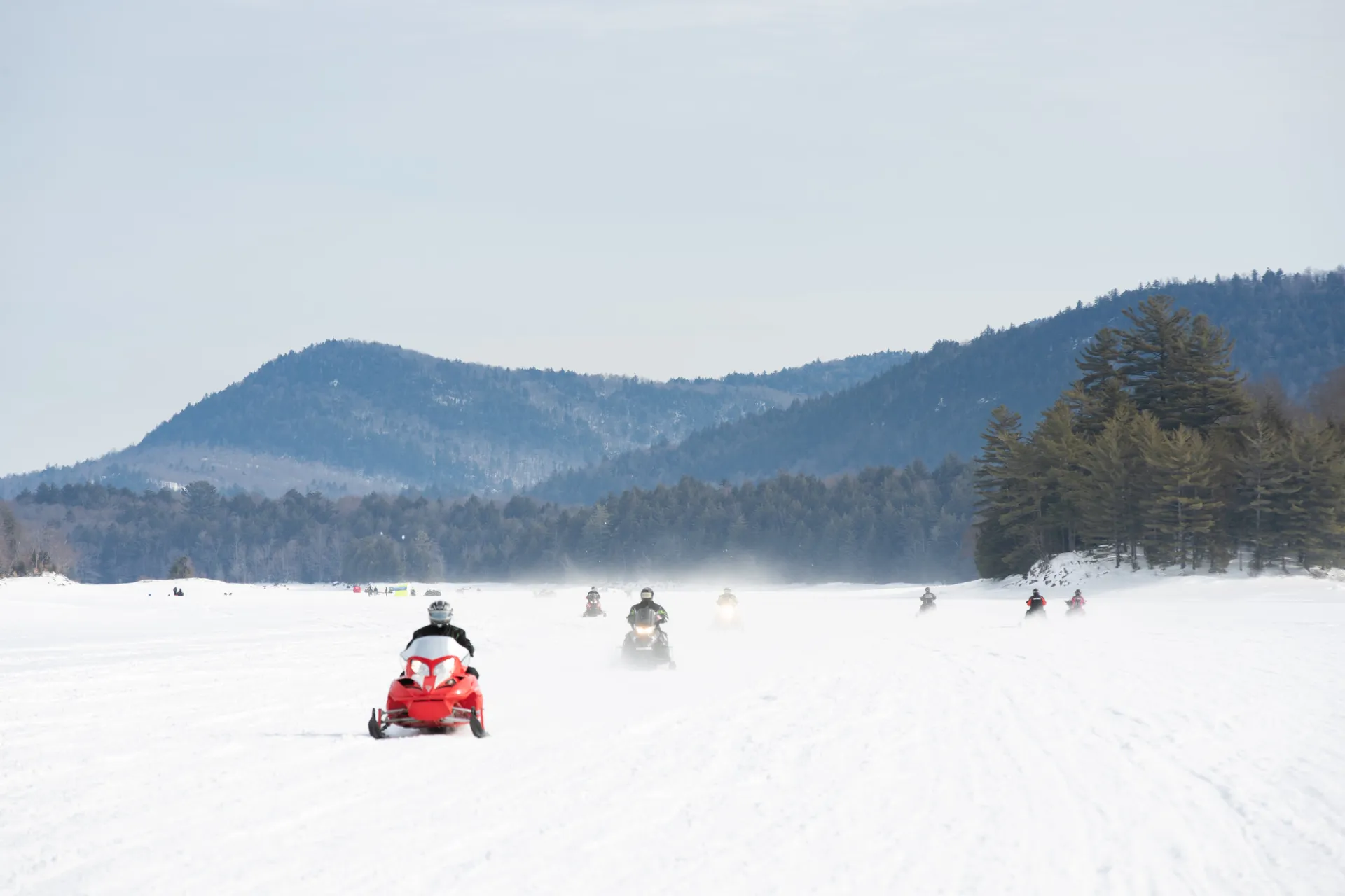 Snowmobilers on a frozen lake